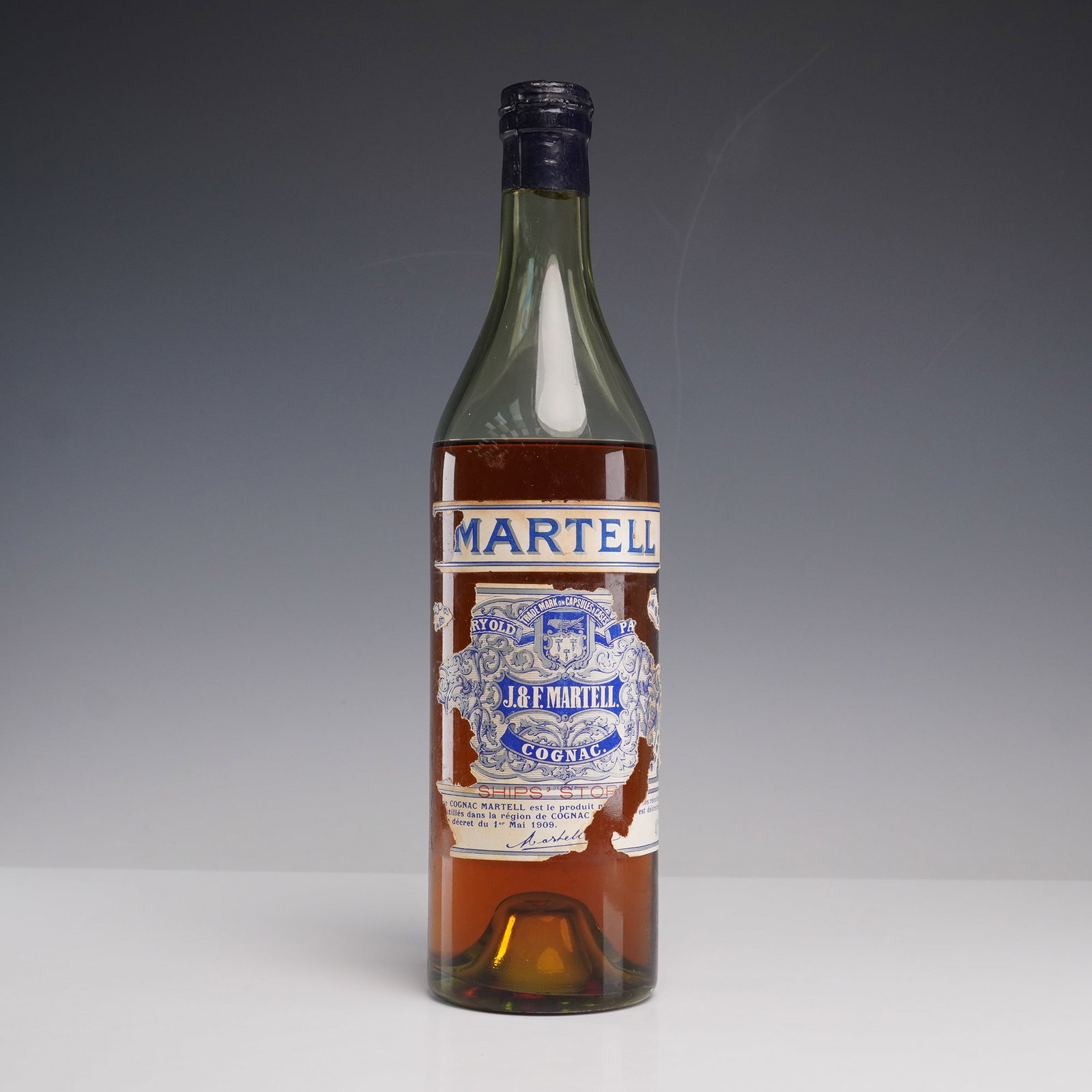 Martell Very Old Pale Cognac: A vintage bottle of Martell Cognac with original label and capsule marked Very Old and Ships Stores. The bottle shows the classic J and F Martell branding with embossed seal and paper label. A collect