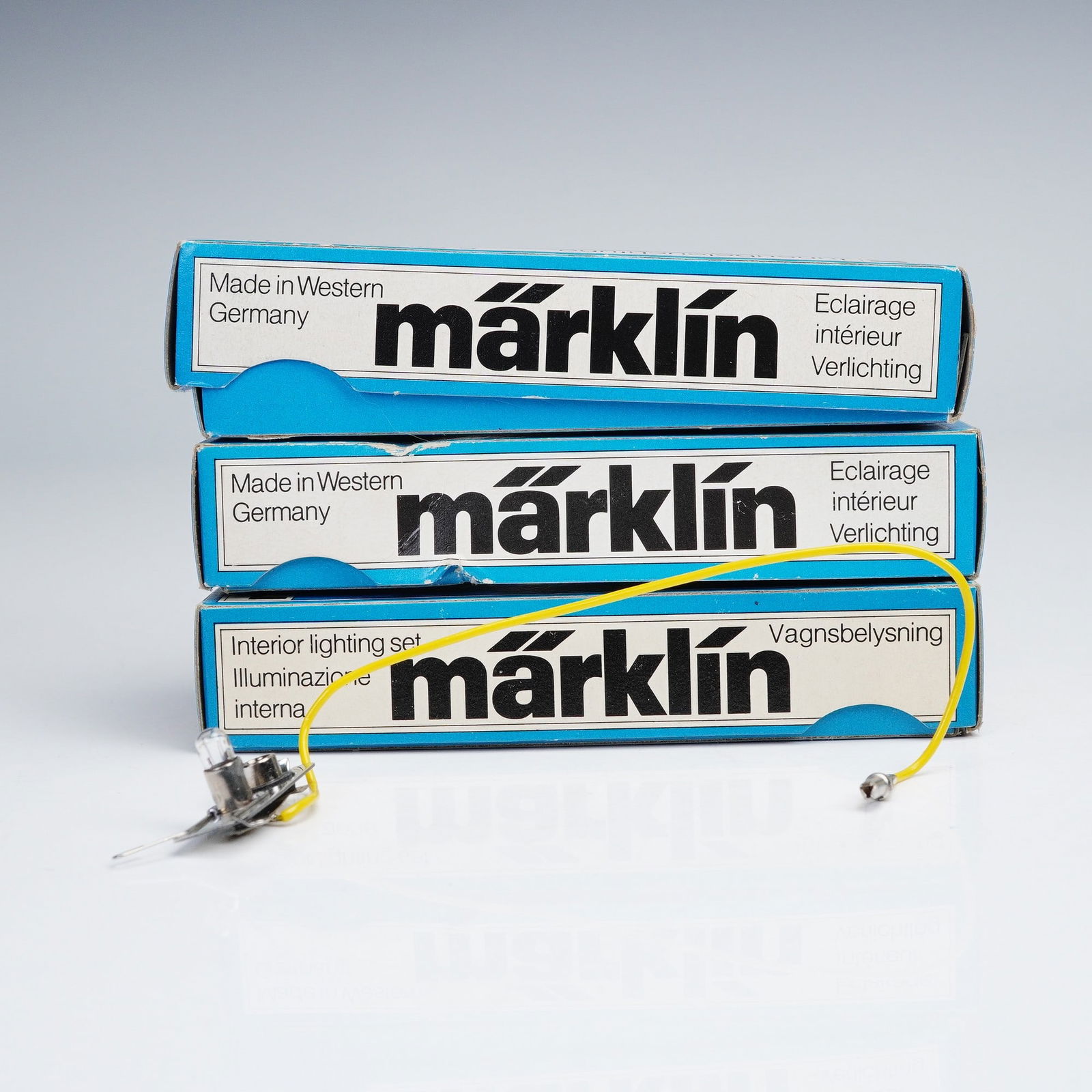 3pc Marklin Interior Lighting Set, HO7077: This lot includes three Marklin HO scale interior lighting sets. Each set is housed in its original blue box labeled in multiple languages. The packaging indicates these sets were manufactured in West