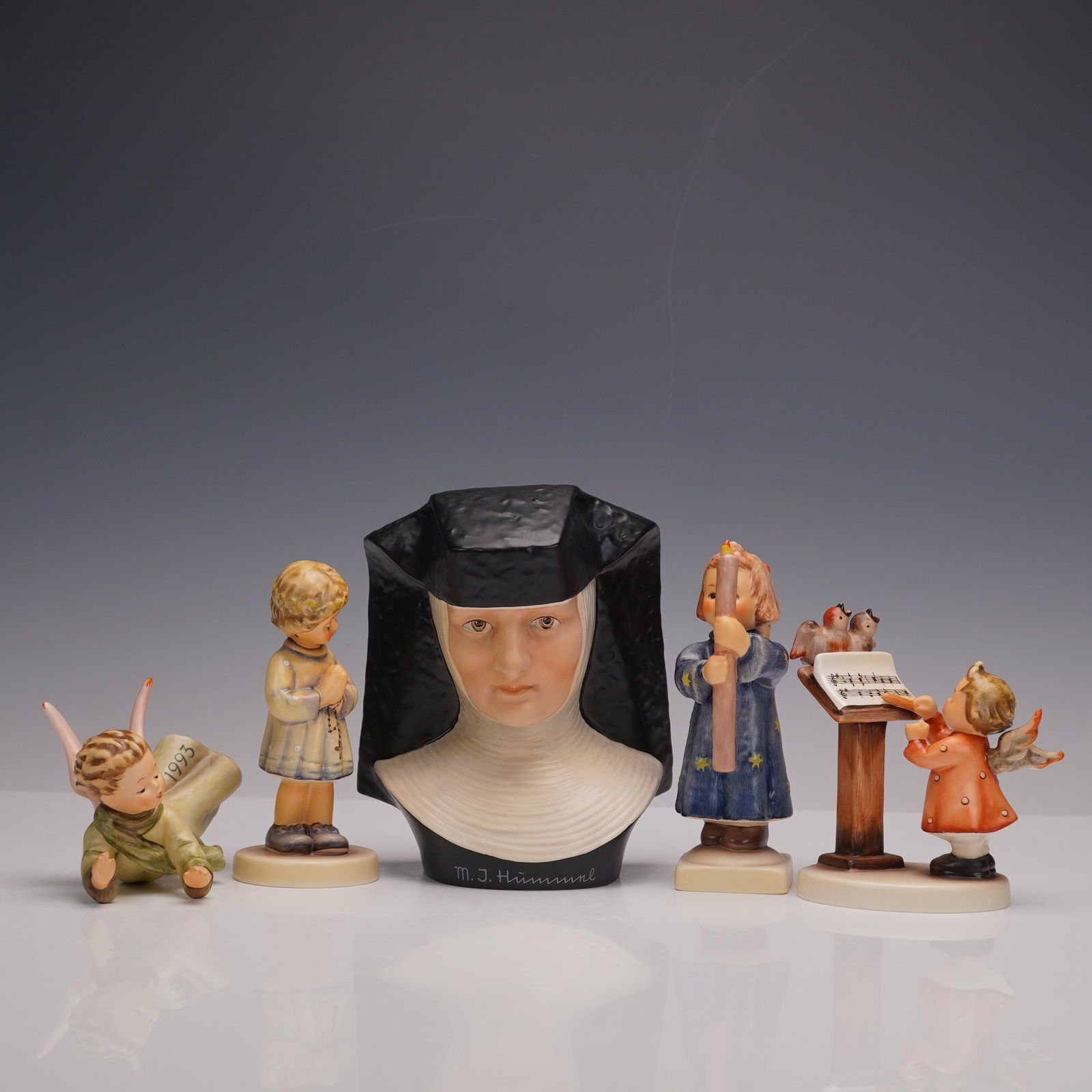 5pc Goebel Hummel Angelic and Devotional Figurines: This charming collection of five Goebel Hummel figurines showcases exquisite hand painted detail and delicate character. Included are Sister Maria Innocentia Hummel with her serene expression, Peacefu