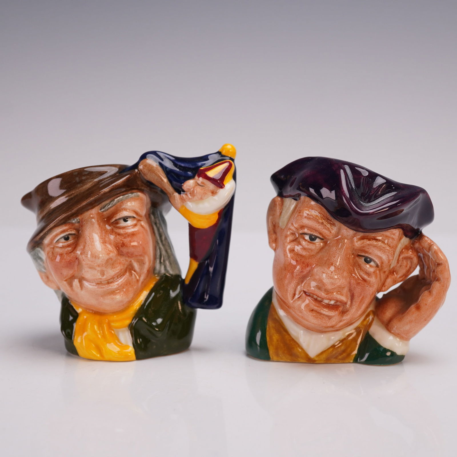 2pc Royal Doulton Mini Character Jug-Punch &Judy D6596 & Ard of Earing D659: Pair of Royal Doulton Mini Character Jugs including Punch & Judy D6596 and Ard of Earing D6594, both designed by David B. Biggs as part of the English Heritage Series. The hand-painted ceramic jugs fe