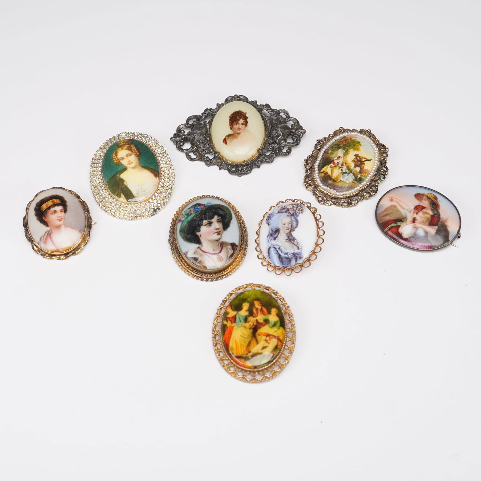 8pc Vintage Portrait Brooch Collection: Grouping of eight vintage brooches featuring hand-painted or transfer-decorated portraits of women in historical, romantic, and pastoral scenes. Subjects include 18th and 19th century style ladies, a 