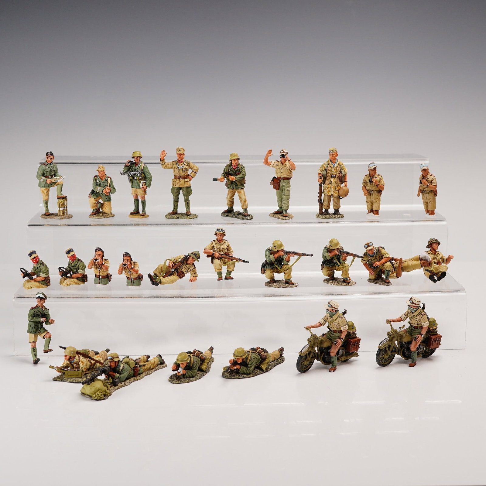 27pc King & Country Afrikakorps Painted Metal Figures: A dynamic 27-piece collection from King & Country's renowned Afrikakorps series, featuring a wide range of WWII-era German troops in lifelike desert combat poses. This lot includes standing and crouch