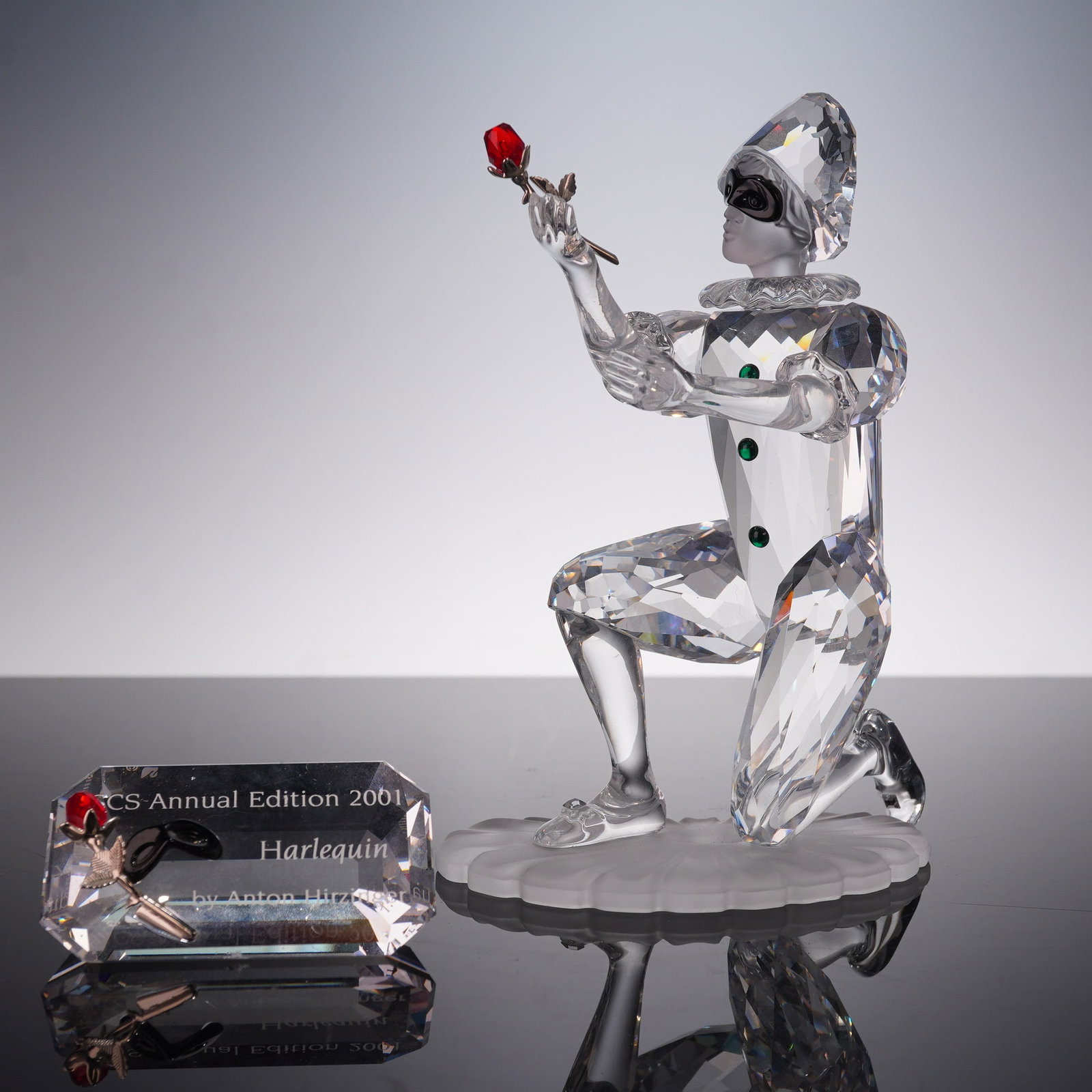 2pc Swarovski Crystal Figurines, Harlequin 254044 and Plaque: This exquisite Swarovski Crystal figurine, Harlequin (Item No. 254044), is a stunning representation from the Swarovski Crystal Society (SCS) Annual Edition 2001, designed by the renowned artist Anton