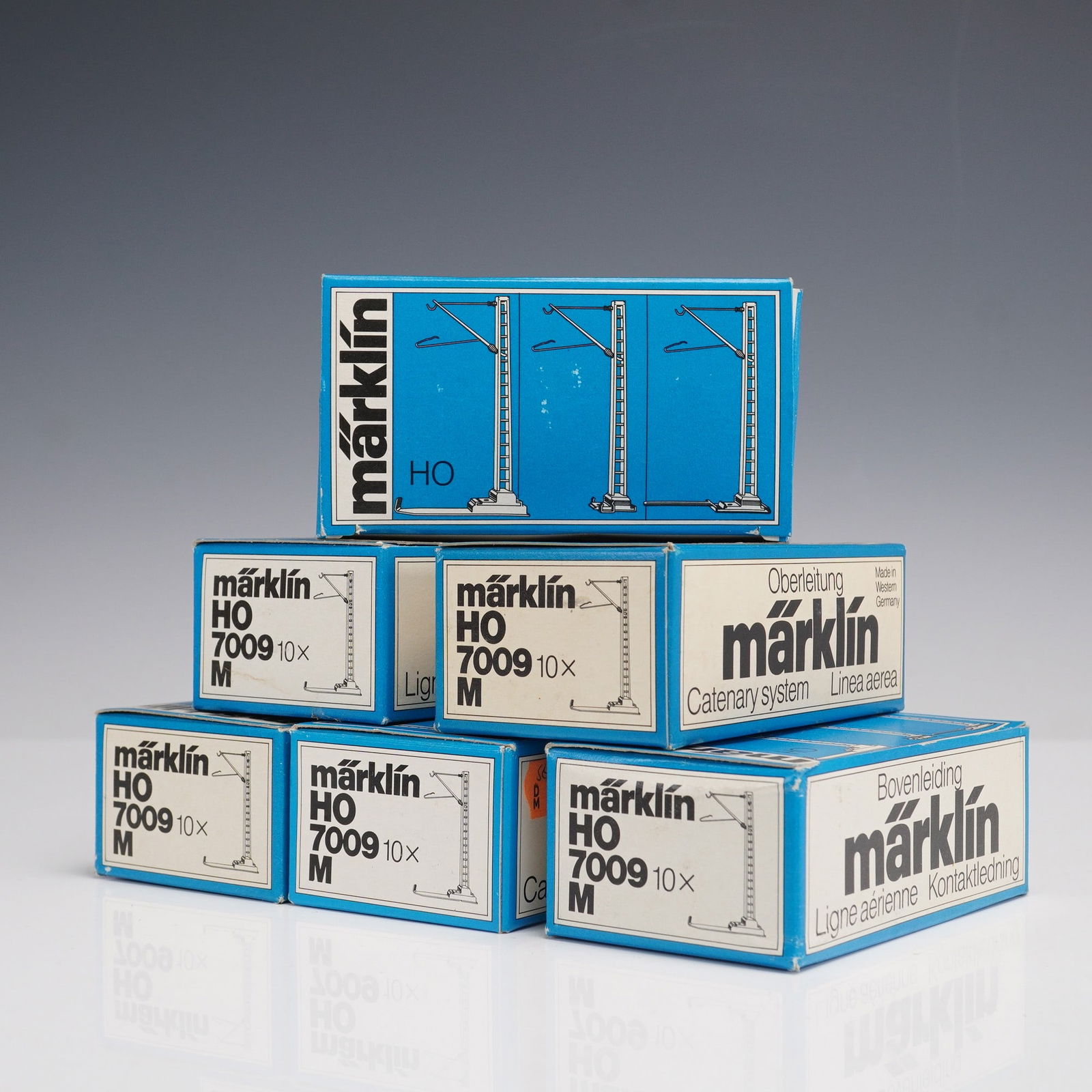 6pc Vintage Marklin HO 7009 Catenary System Masts: This lot includes six original Marklin HO scale catenary system mast sets, model number 7009, each containing ten (10x) masts. These components are part of Marklin's Oberleitung (overhead line) catena