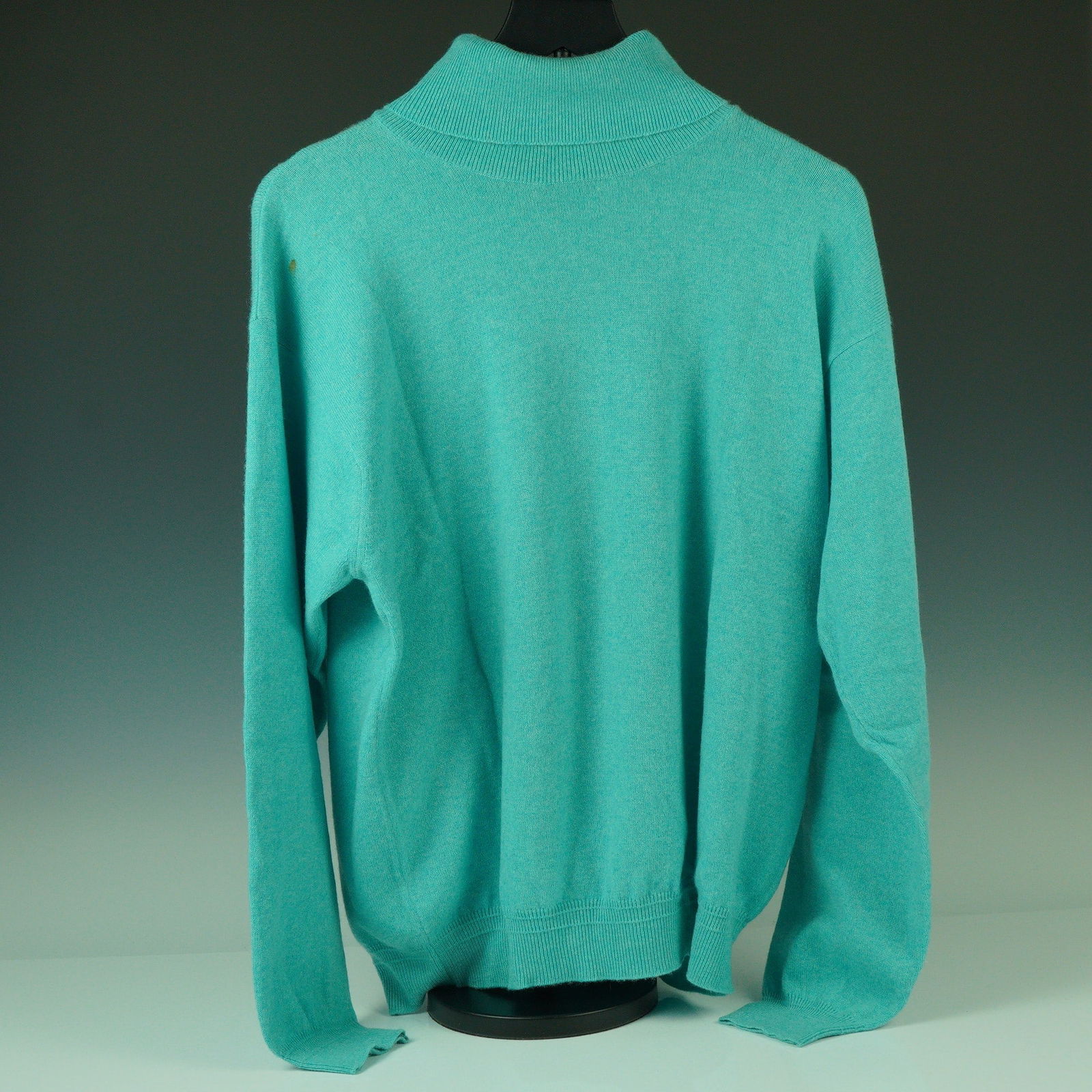 Gianni Versace Aqua Cashmere Turtleneck Sweater: A fresh pop of mid-century color from Gianni Versace, this Italian-made turtleneck sweater is crafted from 100% cashmere in a soft aqua hue. With its wide ribbed collar and matching cuffs and hem, the