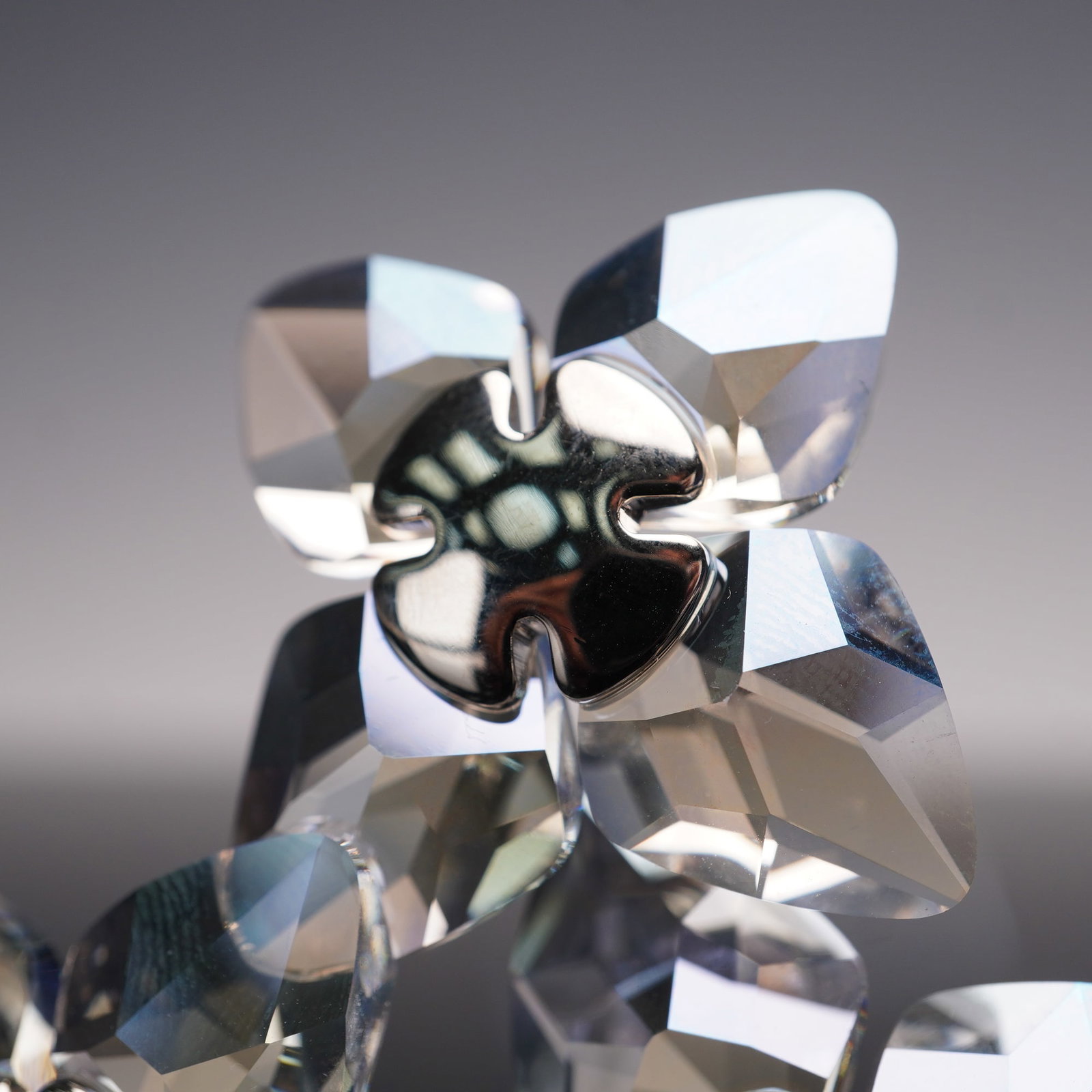 Swarovski Crystal Figurine, Crystal Moonlight Dribella 956805: This figurine features three blossoms with faceted crystal moonlight petals, each accented with slightly pink pearl at the center, creating a refined display of Swarovski craftsmanship. Swarovski back