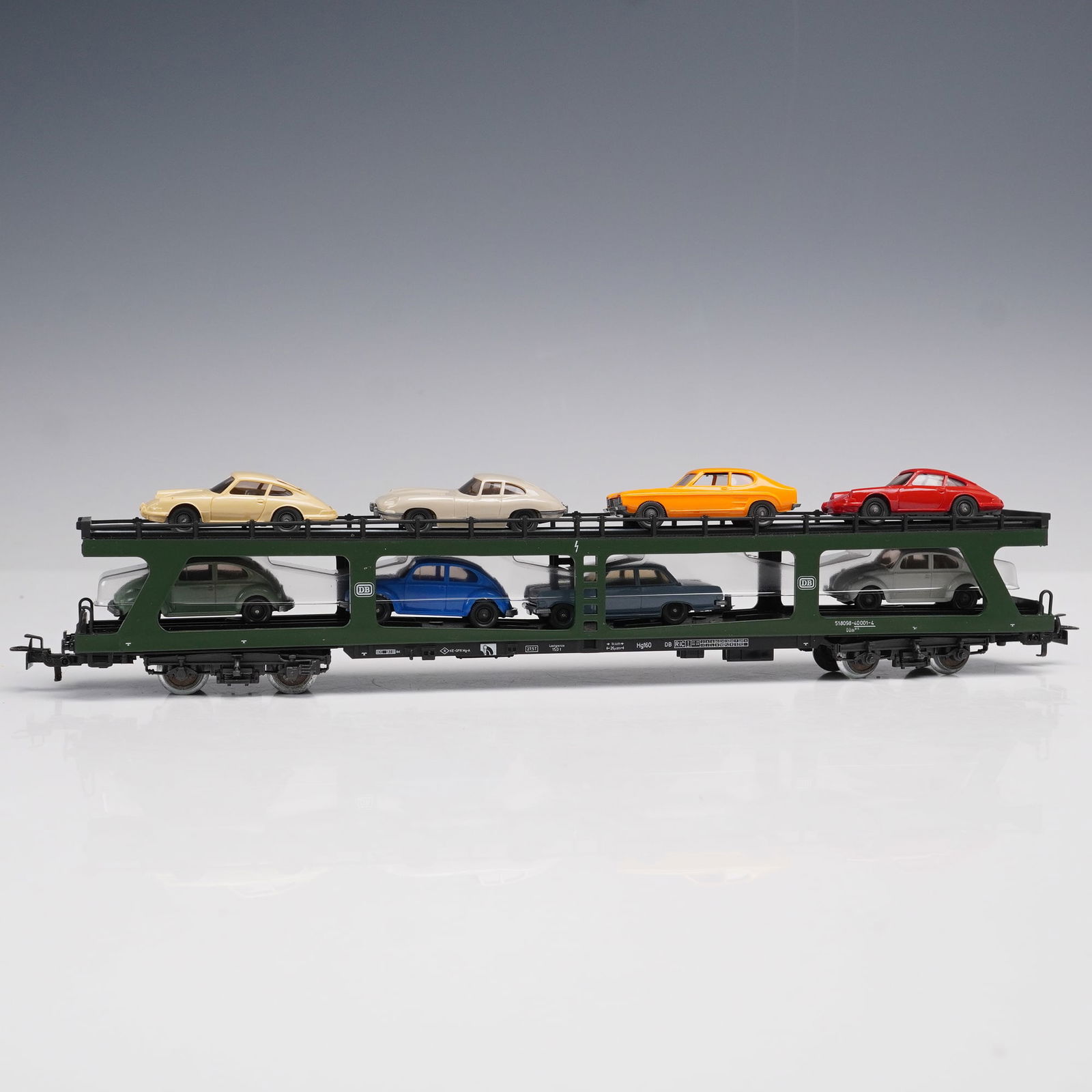 Vintage Marklin HO Scale Auto Transport Car: Offered here is a vintage Marklin HO scale auto transport car, model 4074, complete with a full complement of colorful automobiles. This double-deck transporter is finished in a dark green body with d