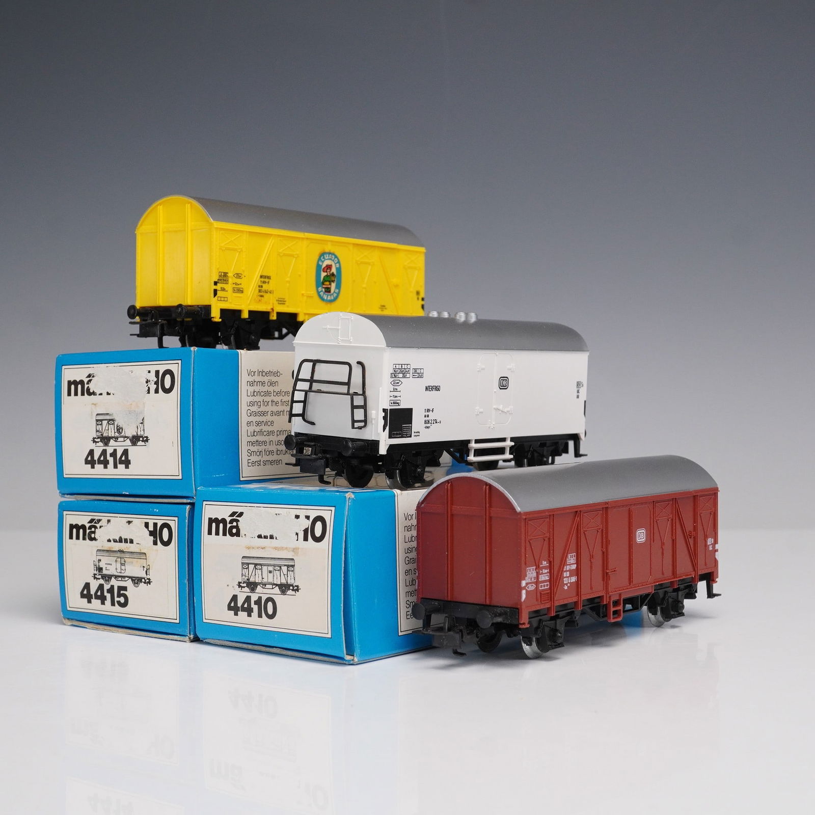 3pc Marklin HO Scale Freight Cars: Lot of three Marklin HO scale freight cars, including 4410 red boxcar, 4414 yellow boxcar with Lowenbrau Munchen logo, and 4415 white refrigerated car. Each retains original Marklin blue box packaging
