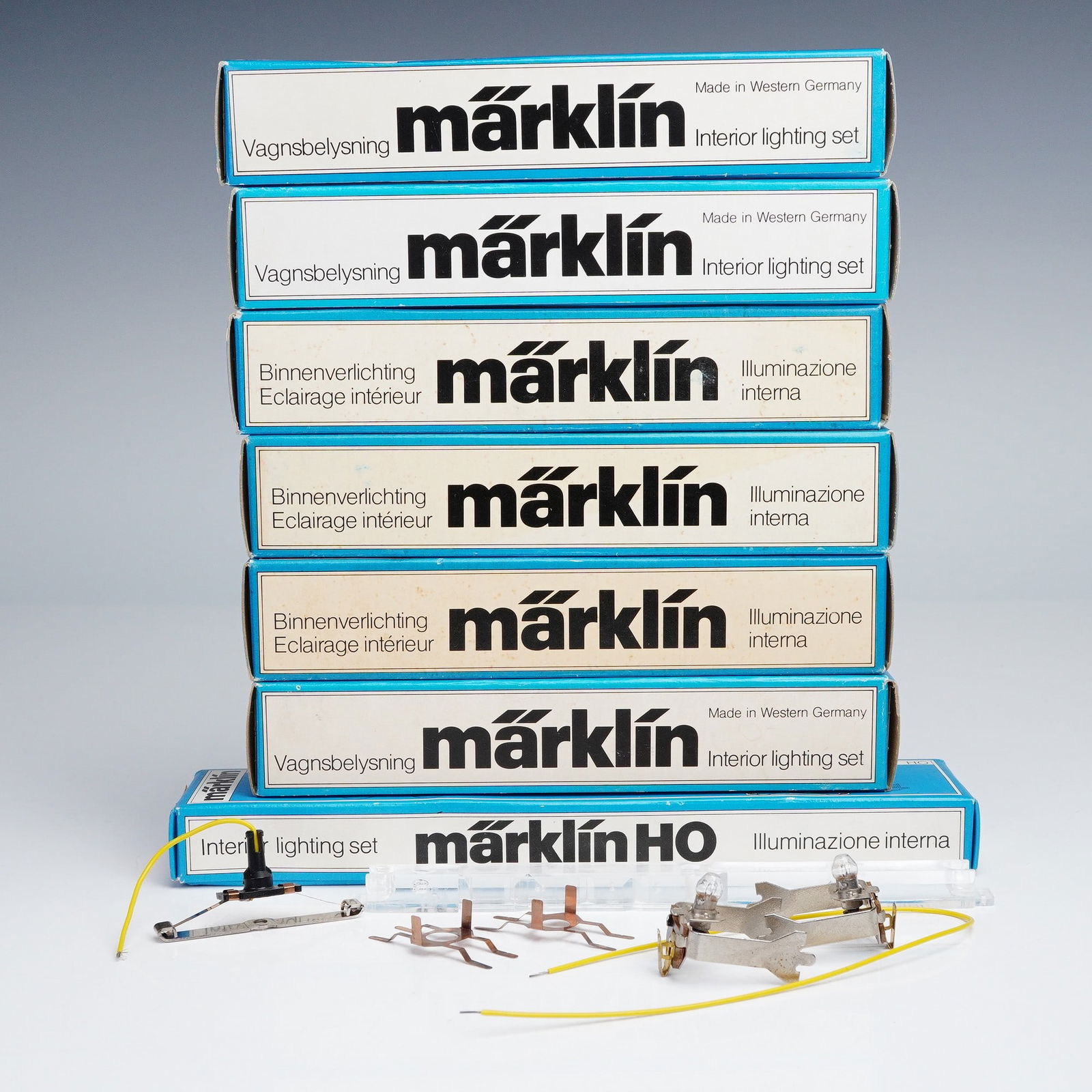 7pc Marklin Railway Accessories Set, Interior Lighting HO 7329 and HO 7320: The lot includes multiple boxed sets marked Made in Western Germany, each containing fittings for HO scale train cars. Visible parts include metal mounting brackets with twin bulb holders and attached