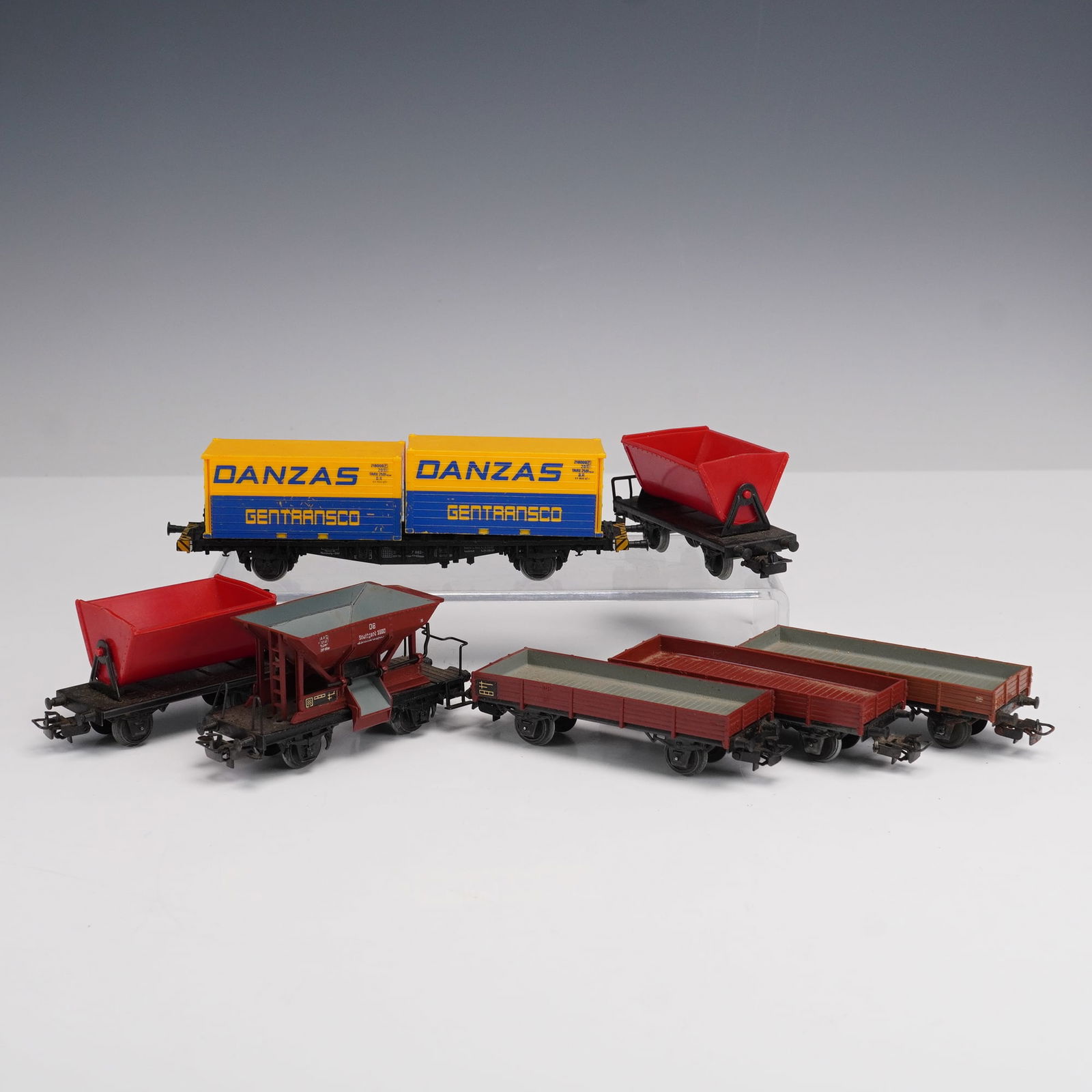 7pc Marklin HO Scale German Freight Cars: This lot features a collection of vintage Marklin HO scale freight cars, made in Germany, showcasing classic European railway design. The group includes a bright yellow and blue "Danzas Gentransco" bo