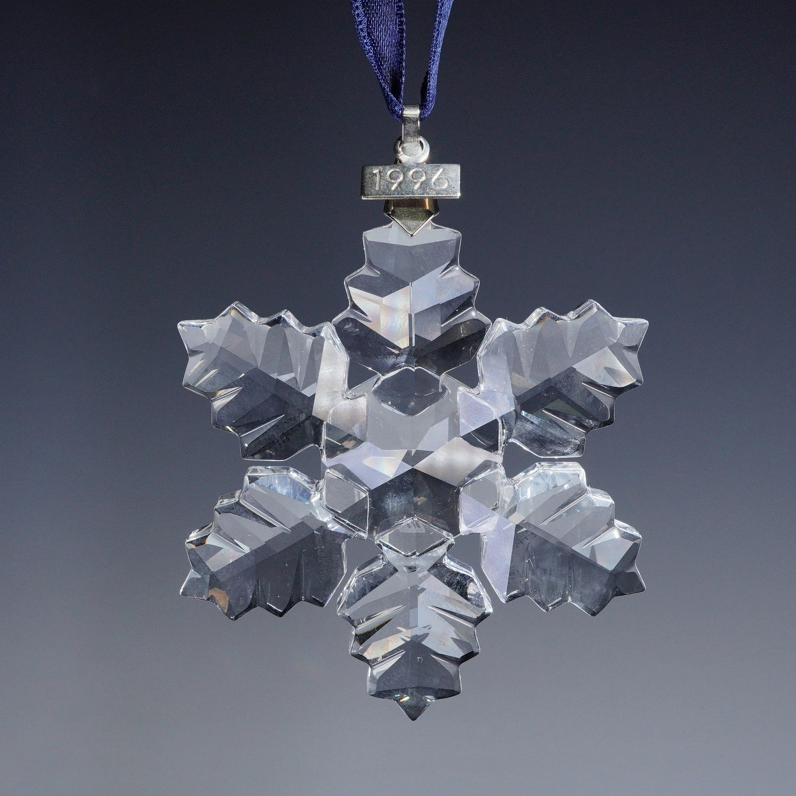 Swarovski Crystal Christmas Ornament 1996 Annual Edition: Swarovski crystal Christmas ornament 199734 Annual Edition 1996. This early edition features a clear crystal snowflake design with precision cut facets, suspended from a blue ribbon with a silver tone