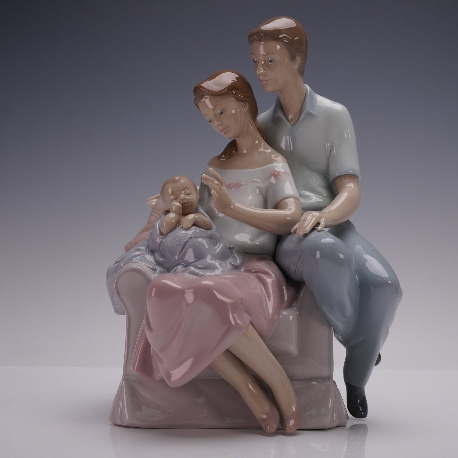 Lladro Porcelain Figurine, A Circle of Love 1006986: A Lladro porcelain figurine titled A Circle of Love, model number 1006986, sculpted by Joan Coderch. The piece depicts a tender family scene with a young couple seated together, gazing lovingly at the