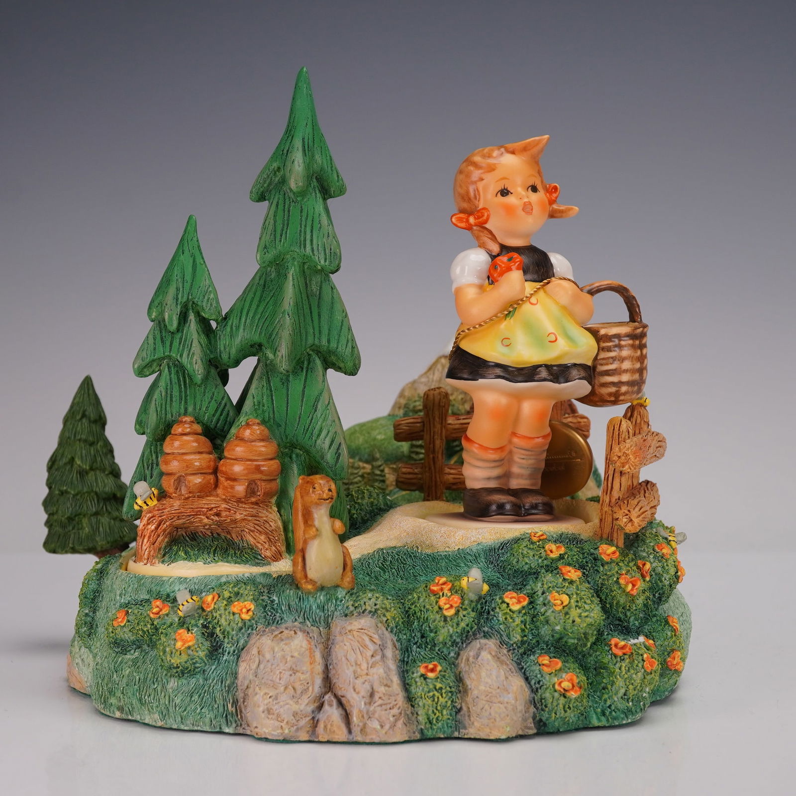 3pc Goebel Hummel Figurine Set, Sister (98) and Summer Stroll (948-D): The set includes a hand-painted porcelain figure of a young girl with braids holding a basket, a scenic base adorned with flowers, trees, a fence, and a small animal, as well as an additional grouping