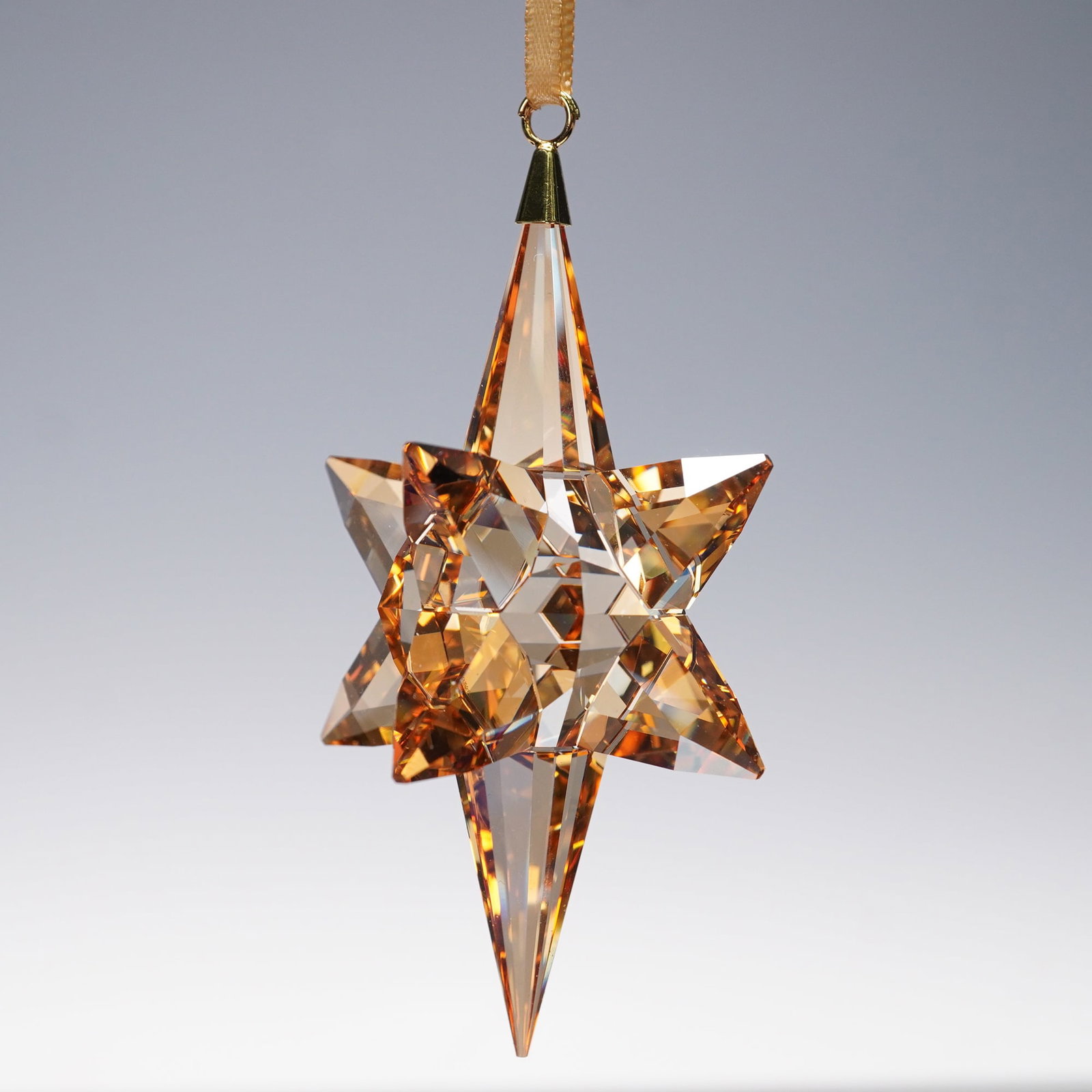 Swarovski Crystal 3D Gold Star Christmas Ornament: Add a touch of magic to your festive decor with this stunning ornament. Exquisitely crafted in gold-tone crystal, this elongated 3D star creates an impressive sparkle thanks to its 302 facets. This it