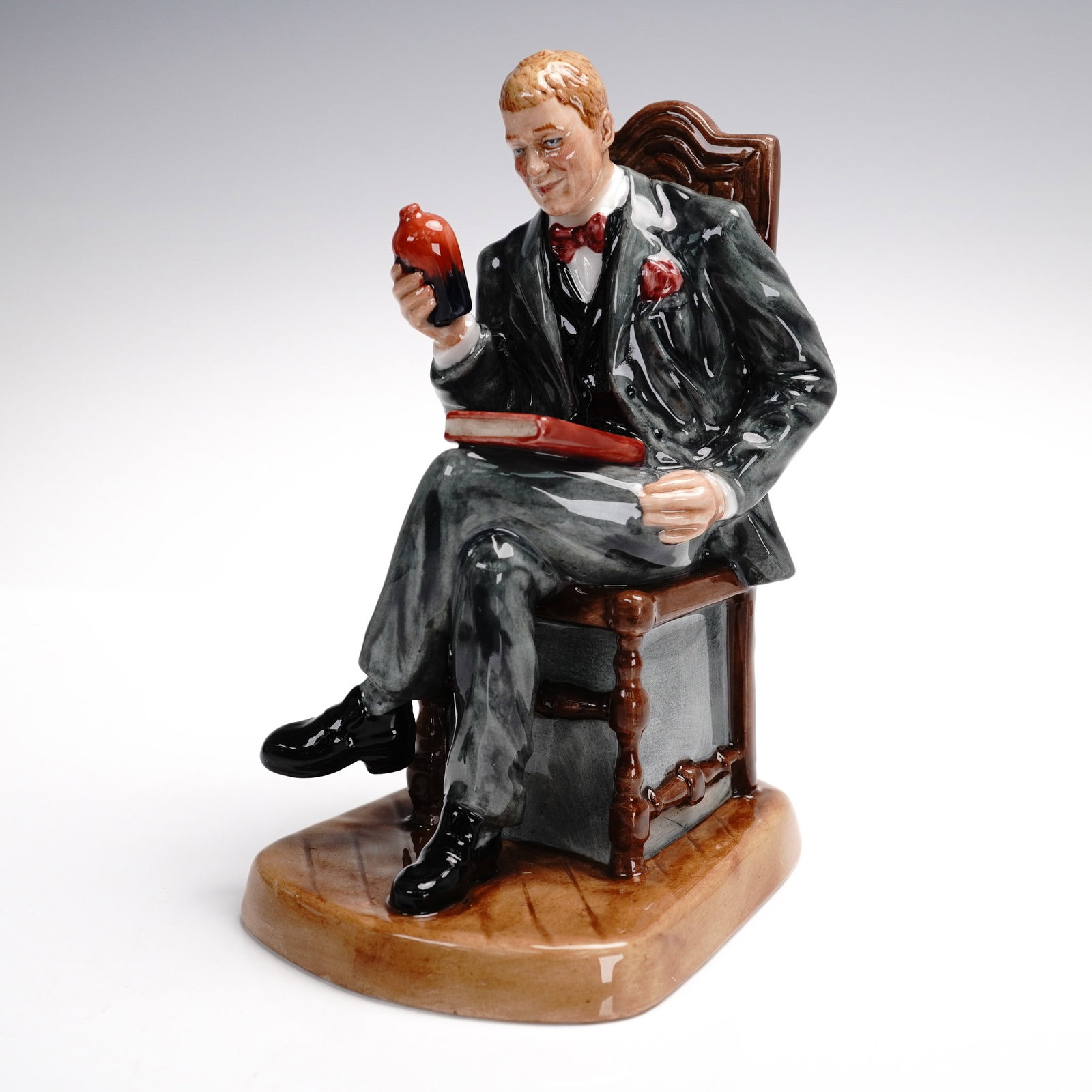 Royal Doulton Figurine, Antique Dealer HN4424: Part of the Professions series. Depicts an antique dealer assessing the value of a flambe vase, seated on his chair. Royal Doulton backstamp. This item has its original box. Box measures: 6"L x 7"W x 