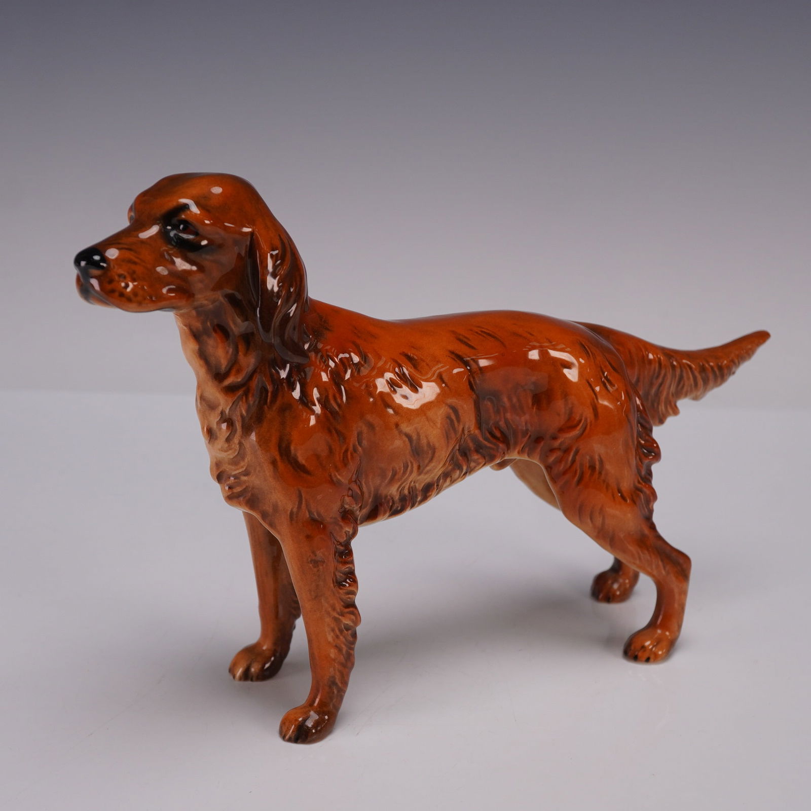 Goebel Porcelain Figurine, Irish Setter Dog CH622: A finely crafted porcelain figurine depicting an Irish Setter, rendered in a rich russet glaze with naturalistic detail to the coat, musculature, and attentive stance. Goebel backstamp. Issued: 1968 D