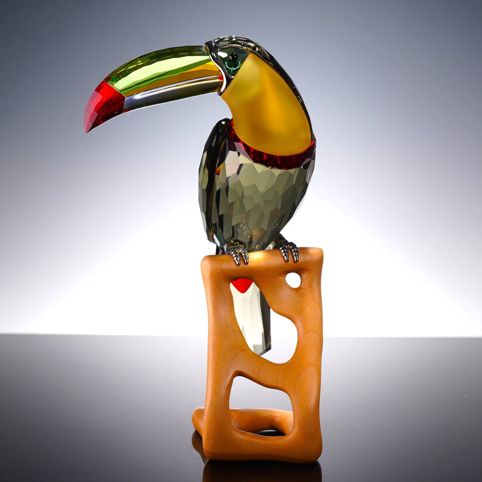 Swarovski Crystal Paradise Birds Figurine, Toucan Black Diamond: Depicting a toucan crafted from faceted Black Diamond crystal with chrome-color talons. The figurine features eyes in Erinite crystal, a multicolored bill composed of Green Beryll, Topaz, Peacock Blue