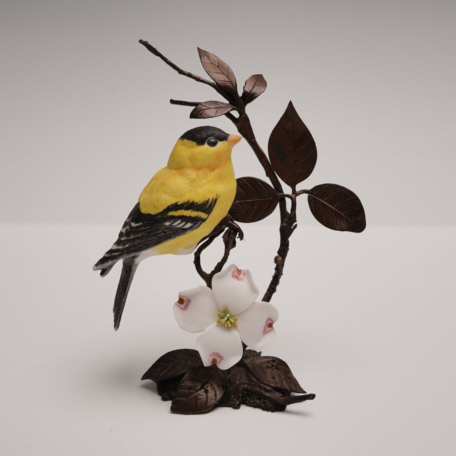 Royal Worcester David Fryer Figurine, Goldfinch: A limited edition of 9,800 figural figure British Birds on Bronze series. The bird is vividly in bright yellow with black and white plumage, poised in lifelike stillness upon a textured branch base. M