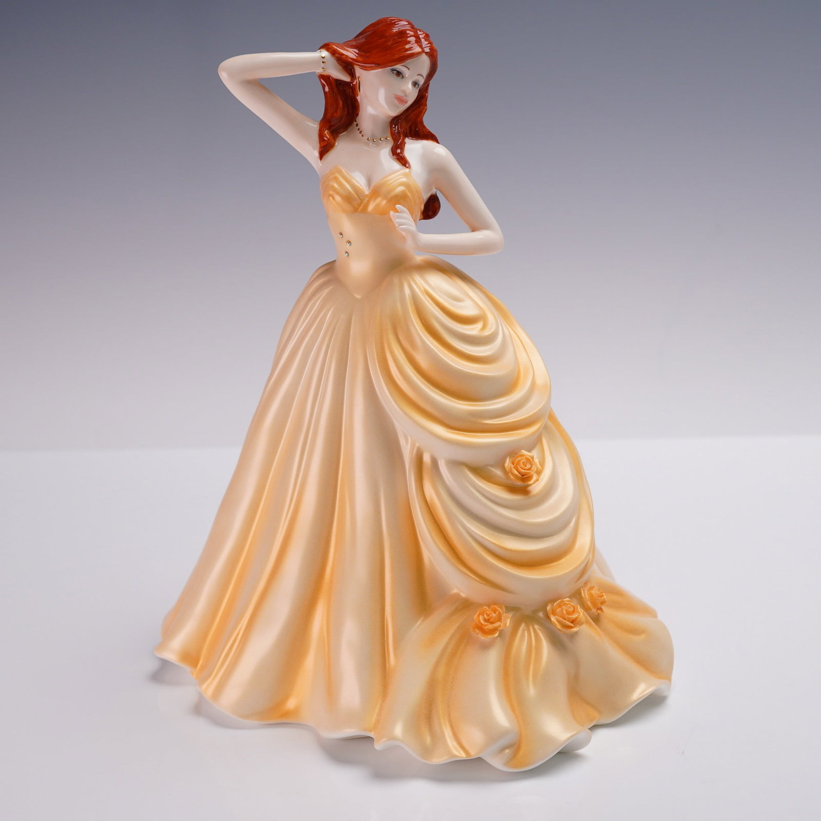 Coalport Figurine of the Year 2009, Ella: Coalport bone china figurine titled Ella, Figurine of the Year 2009. Elegantly modeled and hand decorated in a rich peach and cream gown with sculpted rose accents and flowing ruffles. Part of a limit