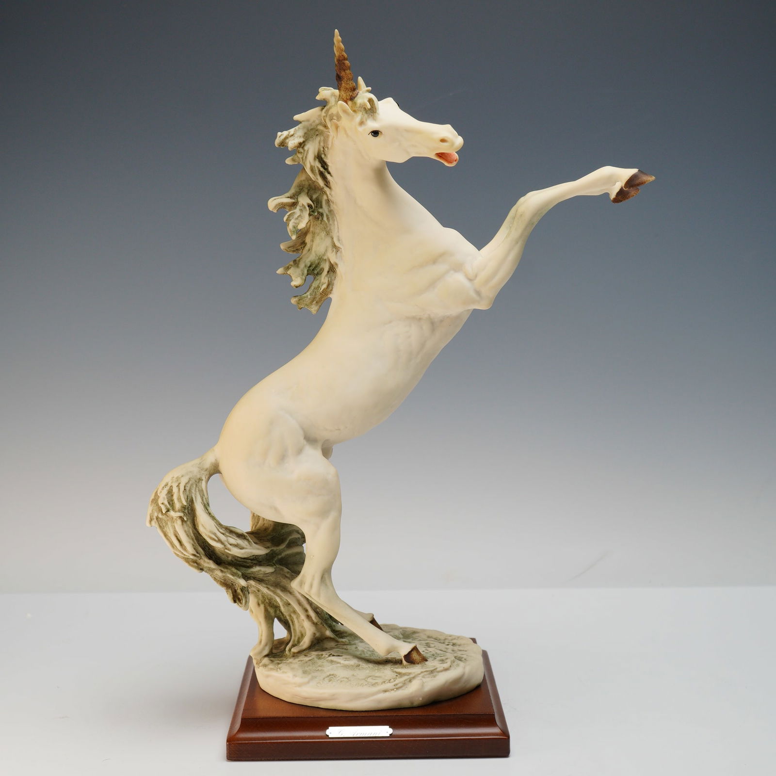 Giuseppe Armani Unicorn Sculpture: Large porcelain figurine designed by Giuseppe Armani depicting a powerful unicorn rearing dramatically on its hind legs with flowing mane and tail. The sculpture is signed G. Armani on the base and ma