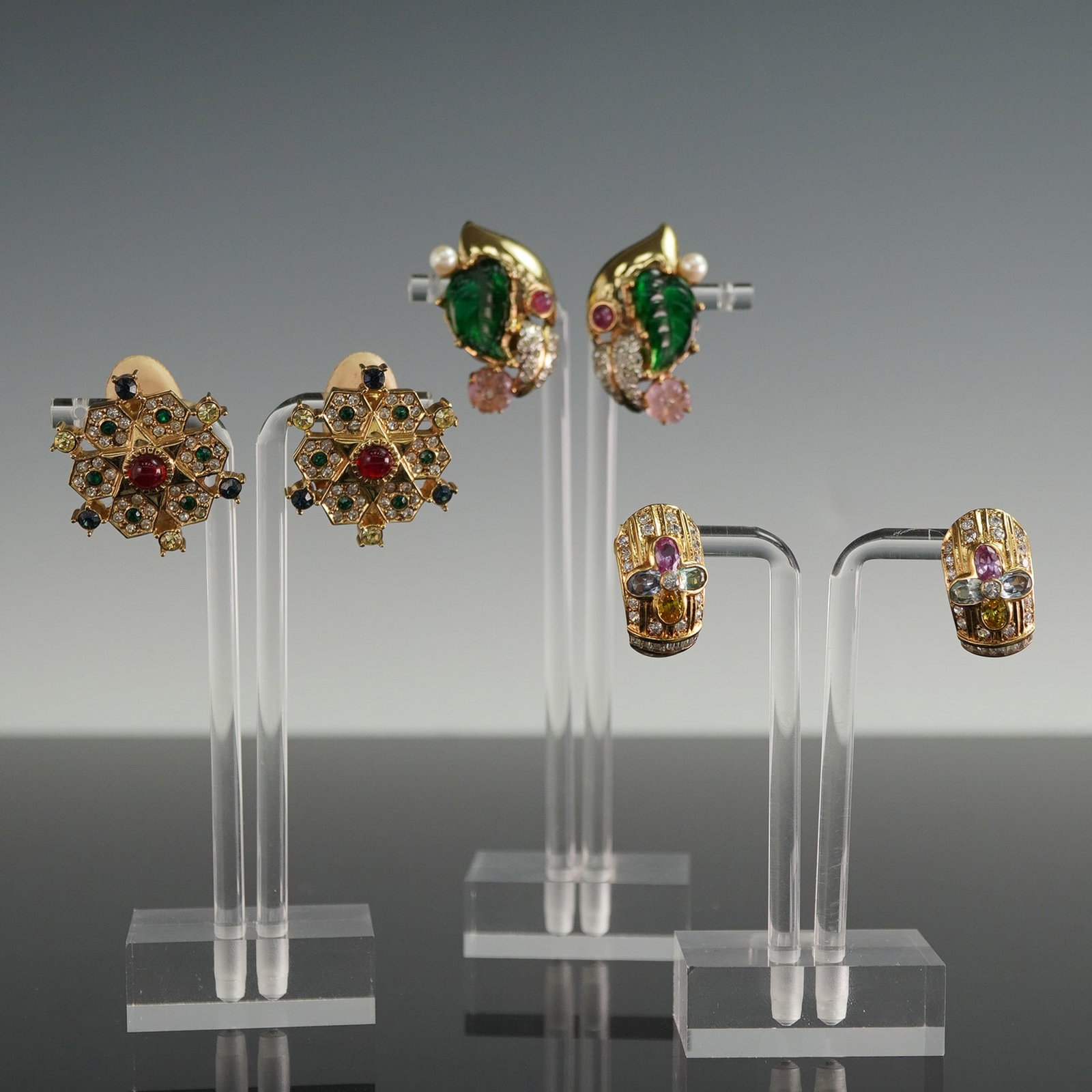3 Pairs of Vintage Clip-On Earrings, Nat Landau Hyman and 18K GP: This stylish set includes three unique pairs of vintage clip-on earrings, each offering its own statement look. The first pair, marked NLH for Nat Landau Hyman, features vibrant green resin leaves acc