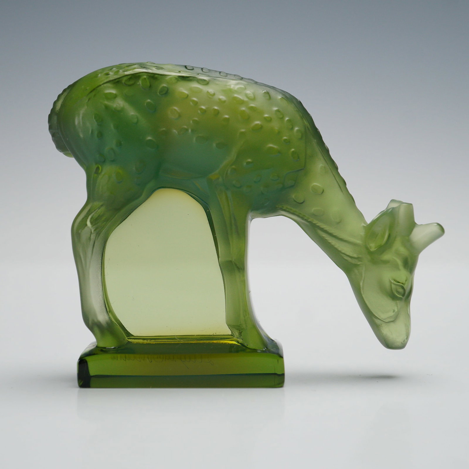 Lalique Crystal Figurine, Sage Green Deer: A finely crafted Lalique crystal figure depicting a grazing deer in sage green glass, beautifully detailed with textured body and graceful form. Signed Lalique France to the base. Issued: 20th century