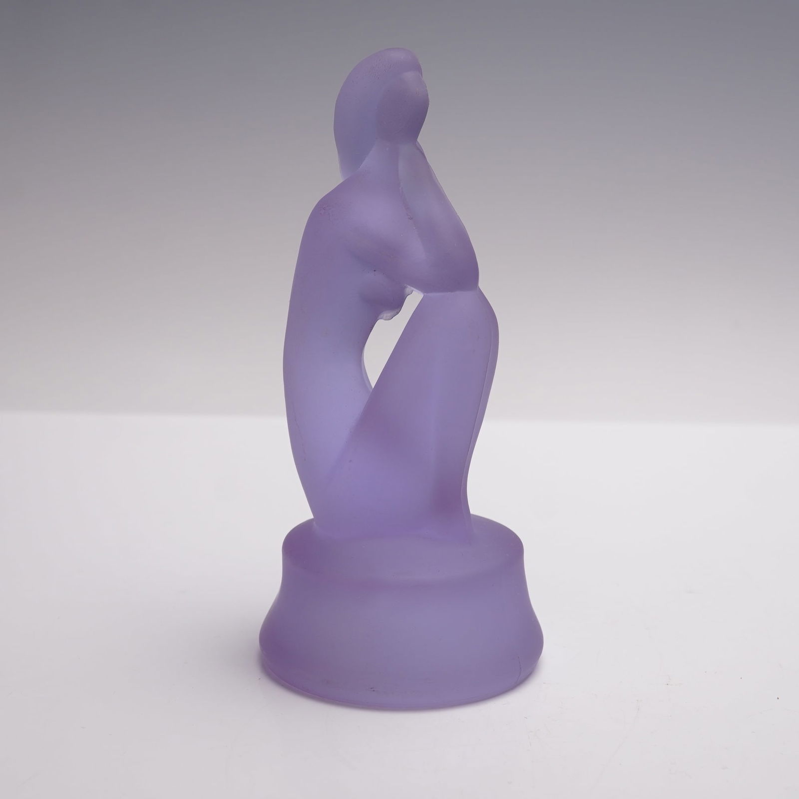 Curt Schlevogt Ingrid Art Deco Glass Sculpture, Lady in The Wind: Rendered in a frosted amethyst glass, this stylized figure captures the flowing, modernist lines characteristic of the 1930s Art Deco period. The abstracted female form is gracefully seated, with her