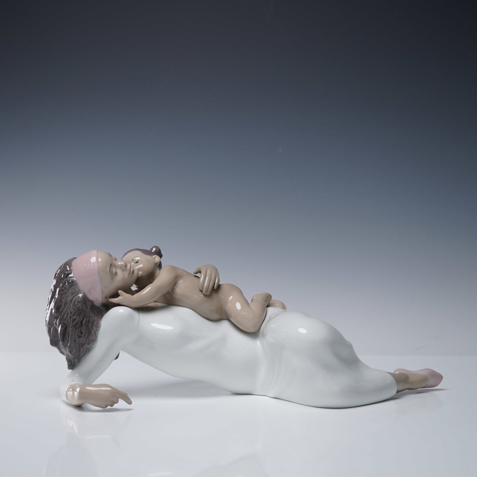 Lladro Porcelain Figurine, Kisses For Mommy 1008205: A touching Lladro porcelain figurine titled Kisses For Mommy, model 1008205. This heartfelt piece portrays a tender scene of a young child embracing her mother, leaning in to give her a gentle kiss. B