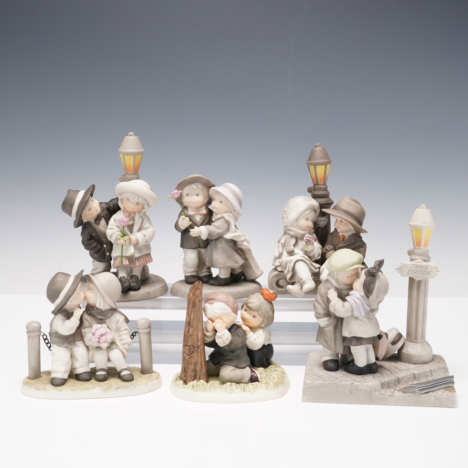 6pc Enesco Figurines, Including We've Only Just Begun, and More: Set of six Enesco porcelain figurines from the 1990s. Each features a romantic couple in vintage-style scenes, including a farewell at the train station and a shared first kiss. Soft pastel tones and
