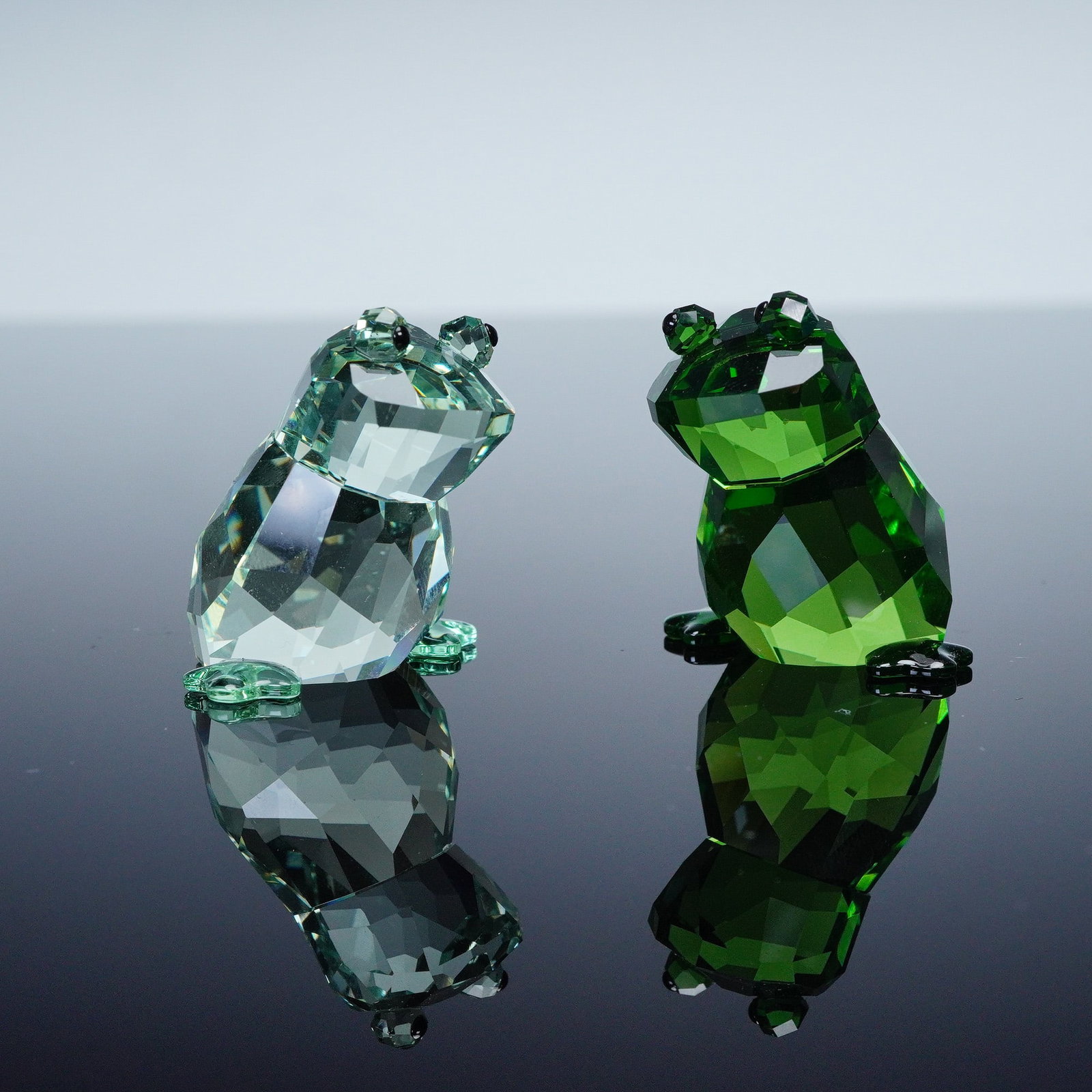 2pc Swarovski Crystal Lovlots Figurines, Angelo and Angelina: A charming duo of cute frog characters making the perfect couple. They sparkle in two different shades of green and feature jet colored crystal for their adoring eyes. Swarovski backstamp. This item h