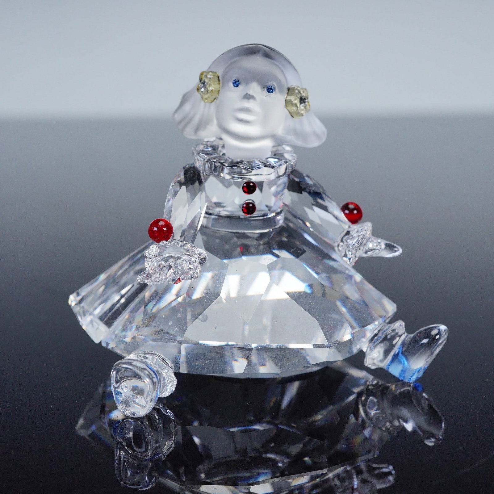 Swarovski Silver Crystal Figurine, Doll: This charming and whimsical crystal doll formed part of the Cheerful Times collection. She has a clear crystal body, with frosted crystal face and hair that help evoke a sense of innocence. Swarovski 