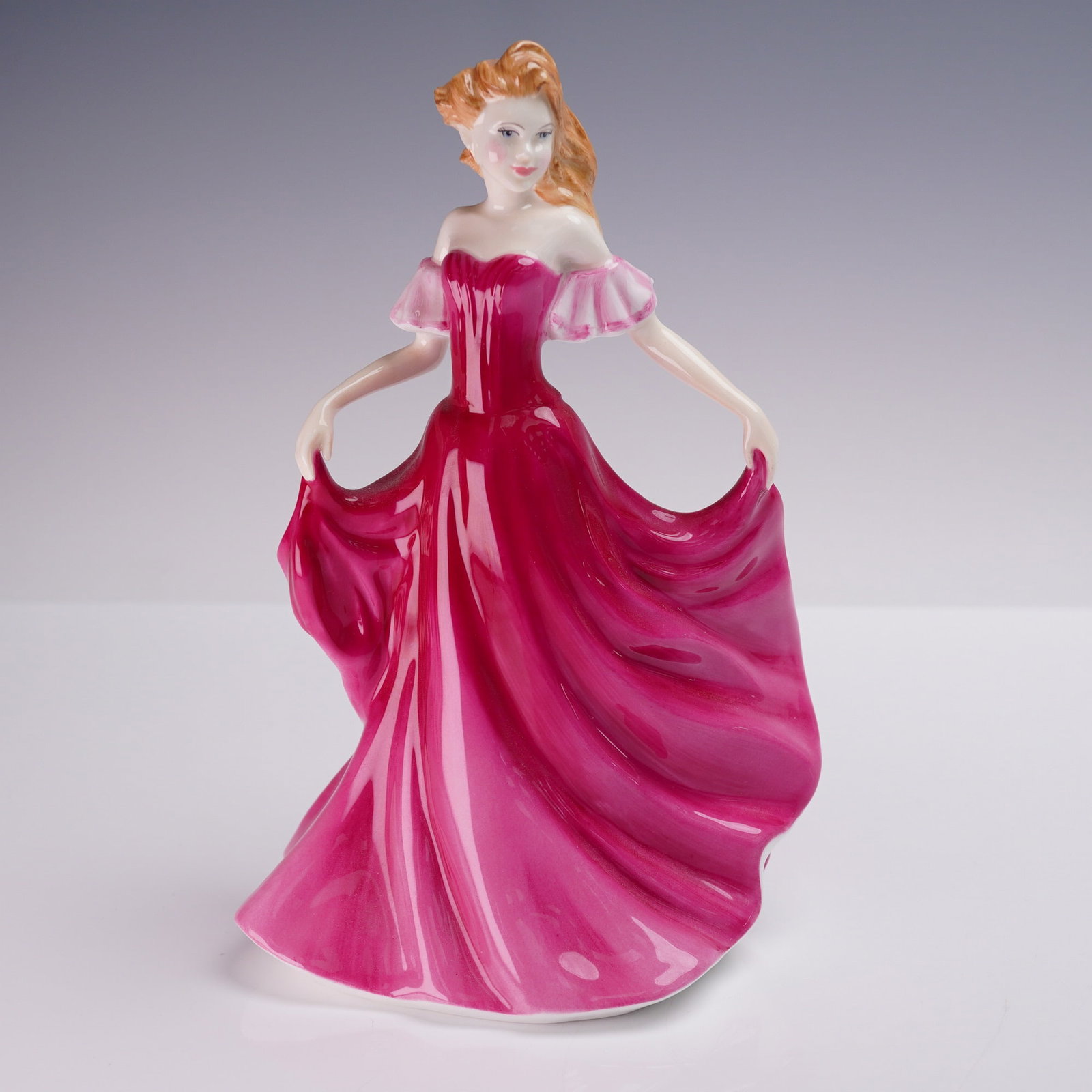 Royal Doulton Figurine, Emma HN3714: A Royal Doulton porcelain figurine titled Emma, HN3714, modeled by Valerie Annand. Issued in 1997, this hand-decorated figure portrays a young woman in a flowing raspberry pink gown with translucent p