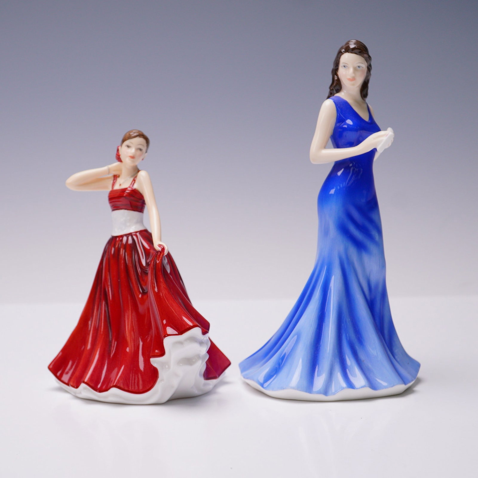 2pc Royal Doulton Pretty Ladies Figurines, Mia HN5541 & Trudy HN5267: A pair of Royal Doulton Pretty Ladies hand-decorated bone china figurines. The first is titled Mia, model HN5541, in a vivid scarlet gown with gathered skirt detail, designed by Neil Faulkner and issu