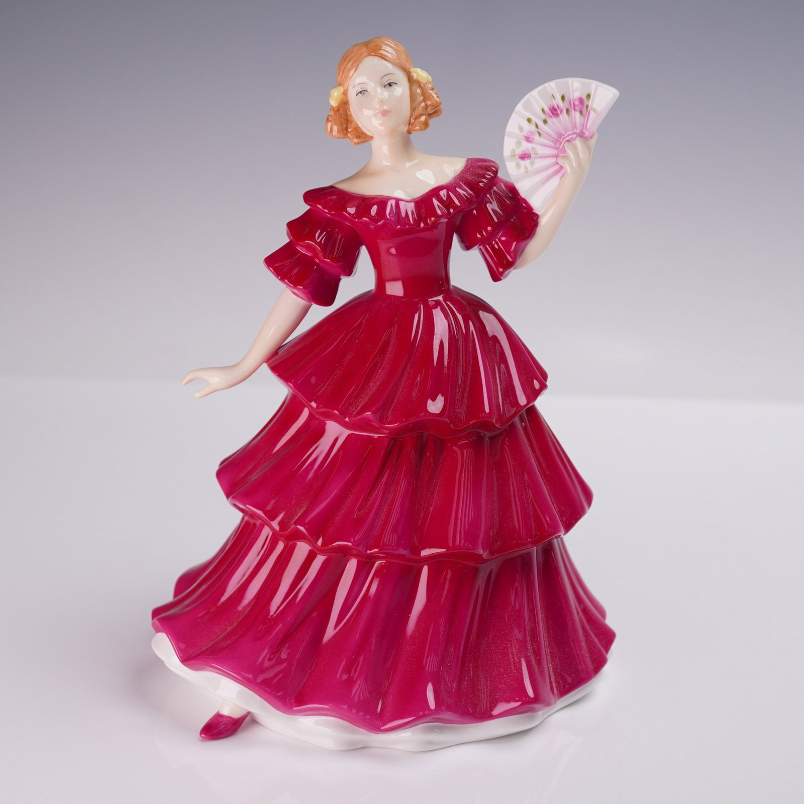 Royal Doulton Figurine, Jennifer HN3447: Charming Royal Doulton Pretty Ladies figurine titled Jennifer, designated as Petite of the Year 1994. Crafted in fine bone china and finished in a rich cranberry red, this hand-decorated figure featur