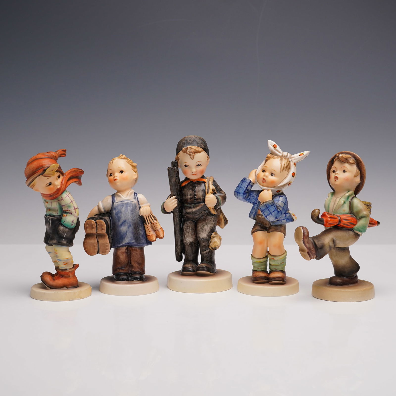 5pc Goebel Hummel Porcelain Figurines: A group of five figurines s, each meticulously hand-painted to depict youthful figures in various charming poses. The selection includes March Winds, Boy with Toothache, Chimney Sweep, Boots, and Glob
