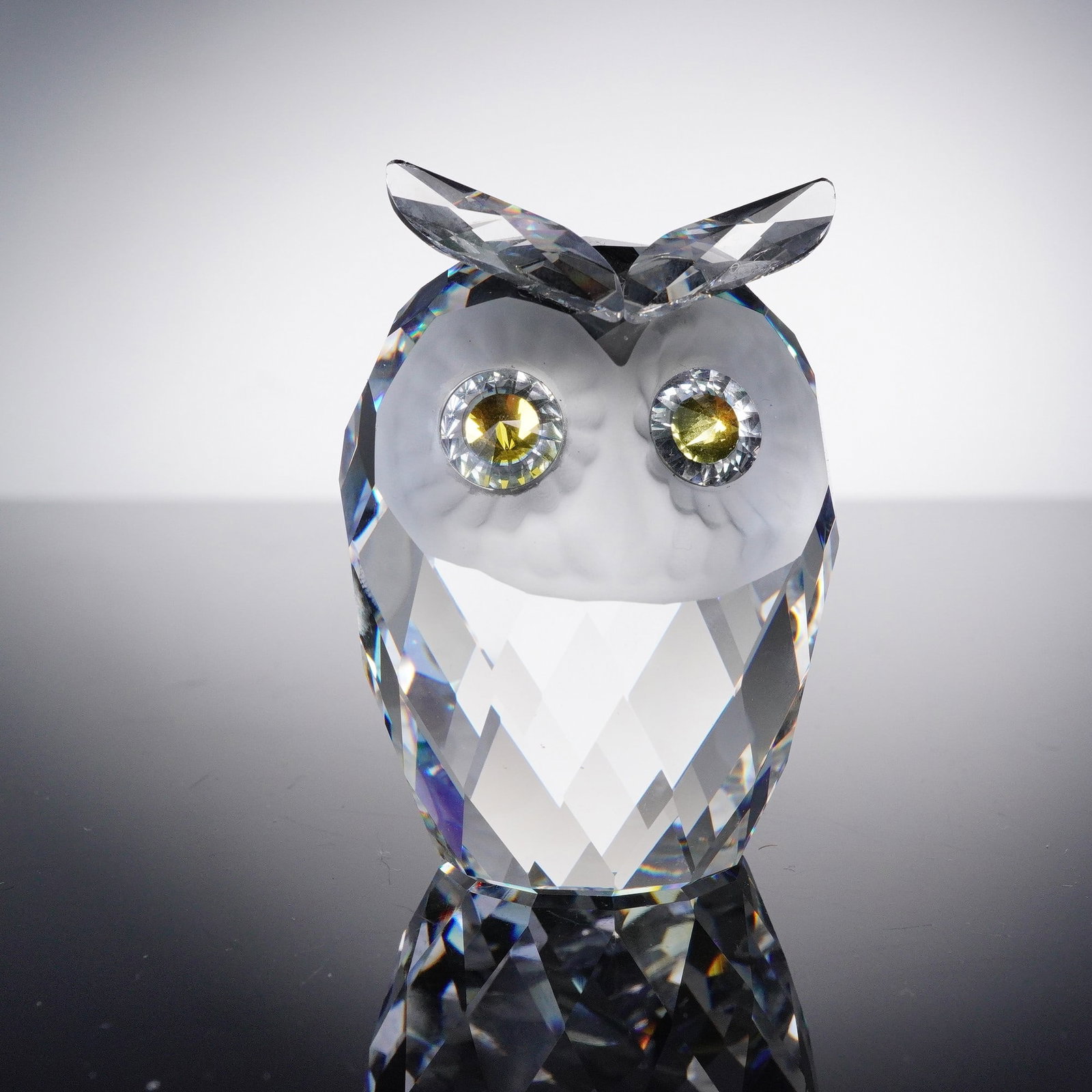Swarovski Crystal Figurine, Owl: Swarovski crystal figurine number 010022, depicting an owl with faceted clear crystal body, frosted head detailing, and expressive yellow crystal eyes framed with clear faceted crystal rings. The piec