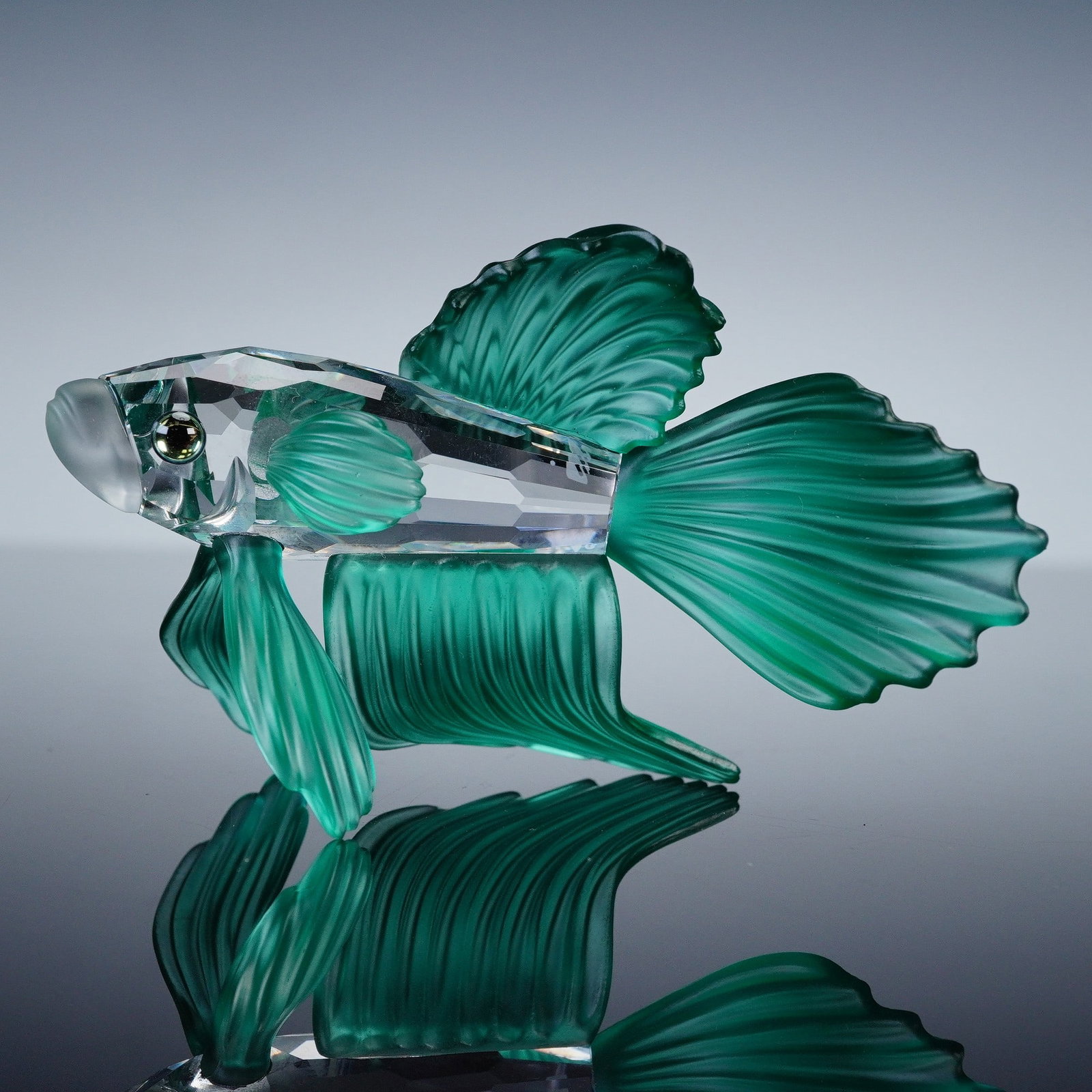 Swarovski Crystal Figurine, Siamese Fighting Fish Green: A finely executed figurine part of the South Sea group. This beautiful fish has a clear crystal body, frosted mouth and green fins and tail. The eyes are accented with gleaming, colored crystal. Swaro