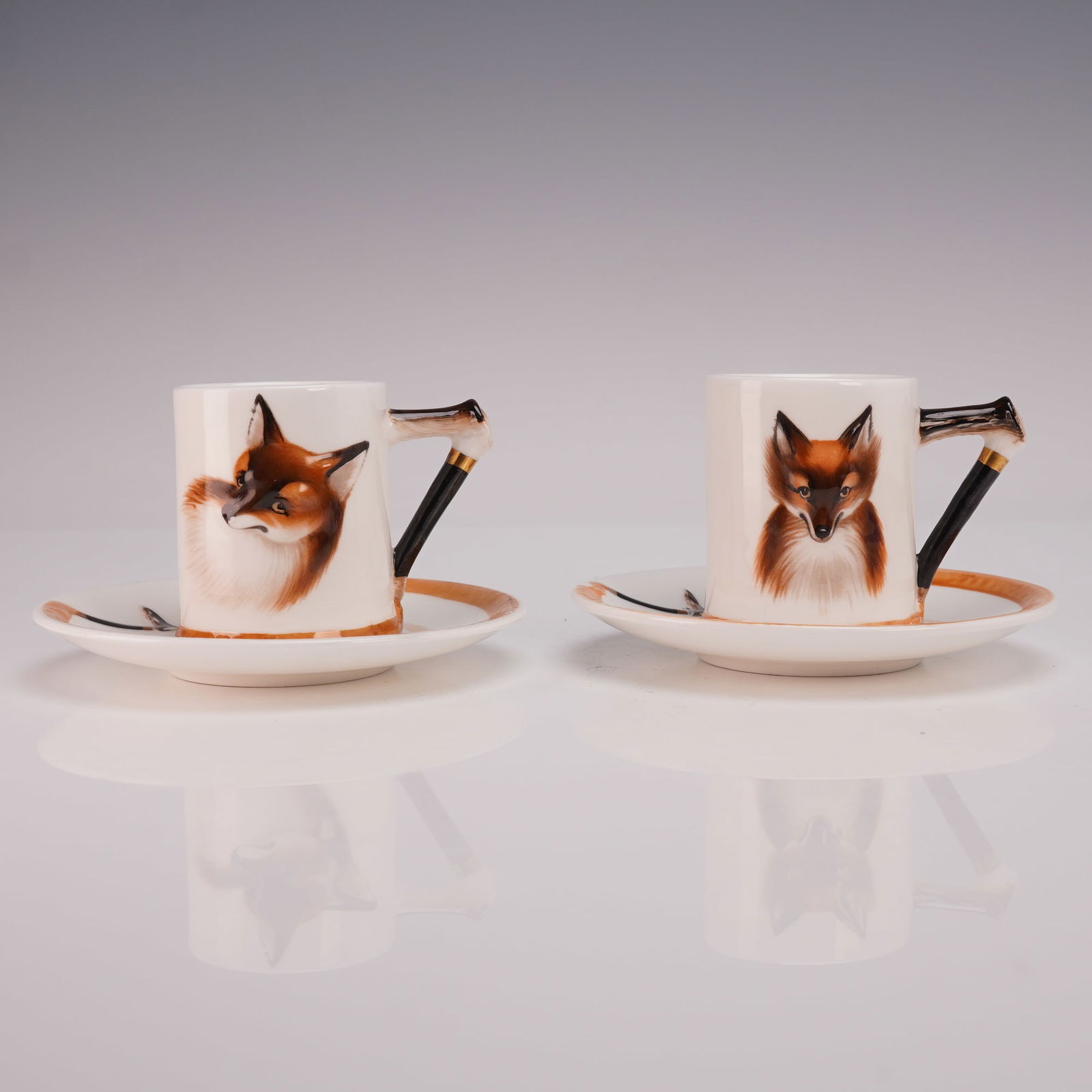4pc Royal Doulton Bone China Cup & Saucer Sets, Reynard the Fox: Pair of Royal Doulton bone china cup and saucer sets decorated with finely hand-painted portraits of Reynard the Fox. Each cylindrical cup features a fox head on the front with a whip-form handle acce