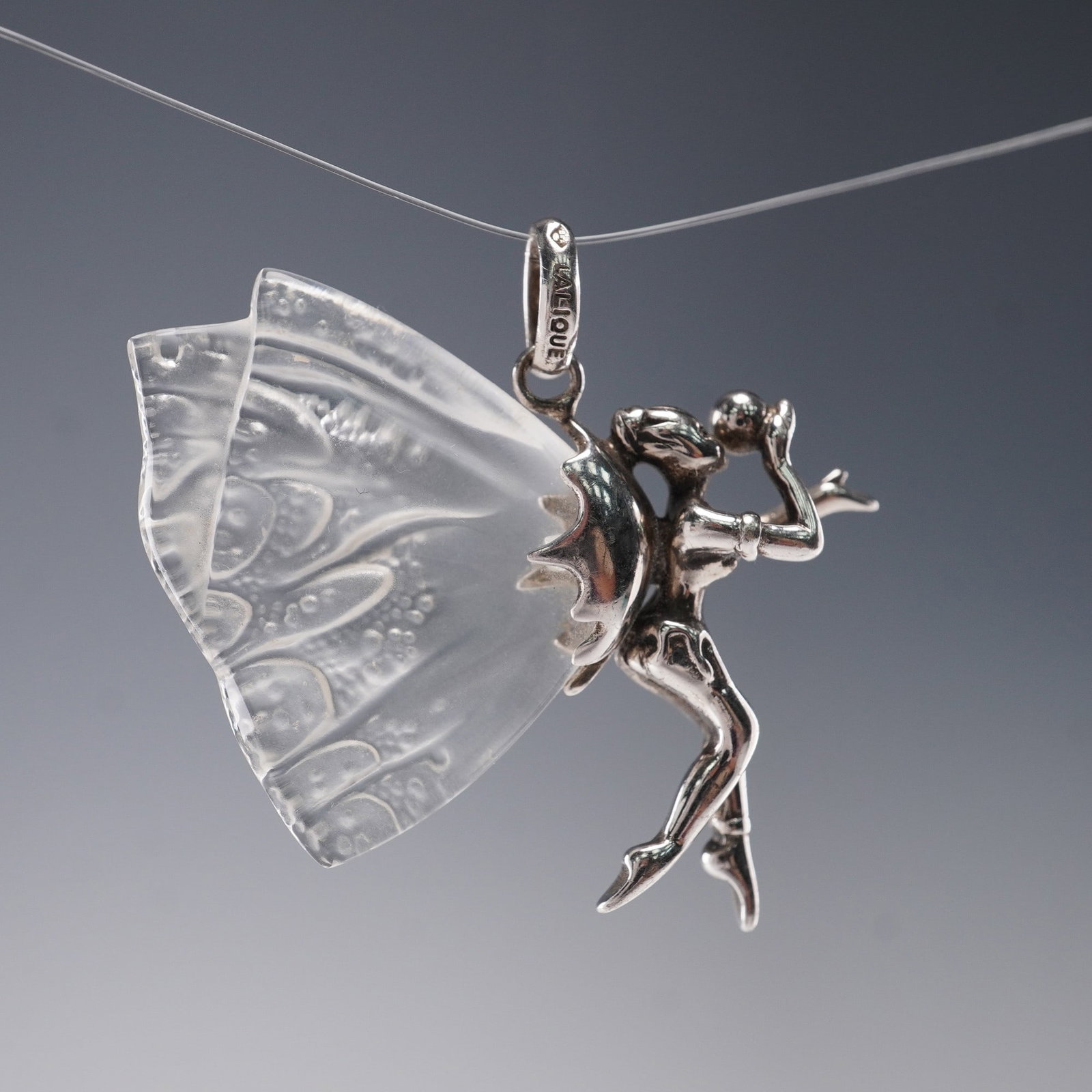 Lalique Chrysalide Fairy Pendant Silver Tone with Frosted Crystal Wings: The Lalique Chrysalide Fairy Pendant showcases a graceful winged fairy, crafted in silver tone with intricately detailed frosted crystal wings that evoke the delicate beauty of butterfly patterns. The