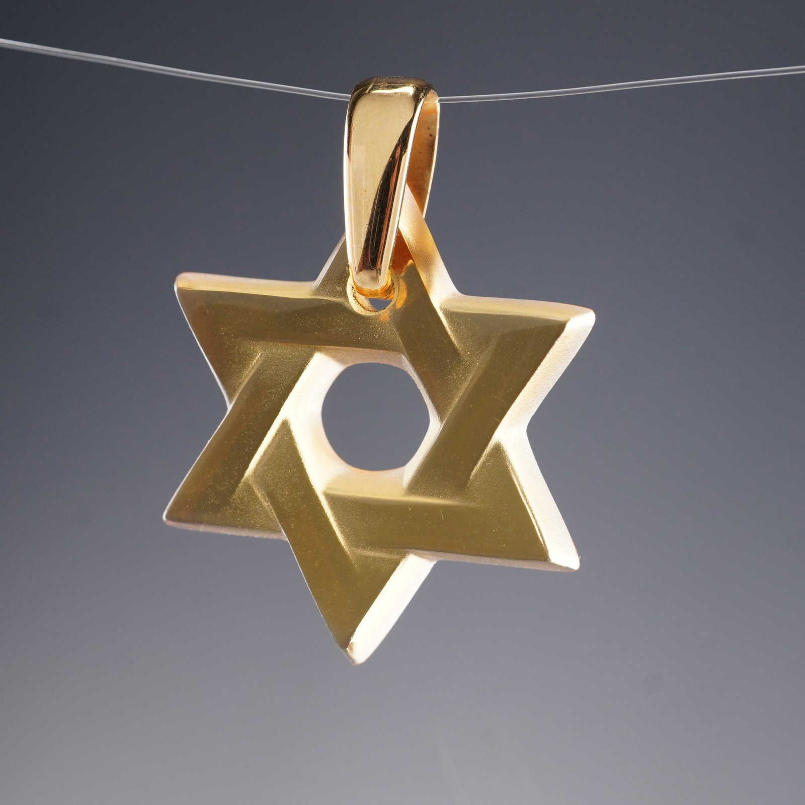 Lalique Crystal Star of David Pendant: This beautifully crafted pendant features the iconic Star of David design, expertly sculpted from smooth, clear crystal with a radiant gold-tone finish around the edges. The piece is signed with the L