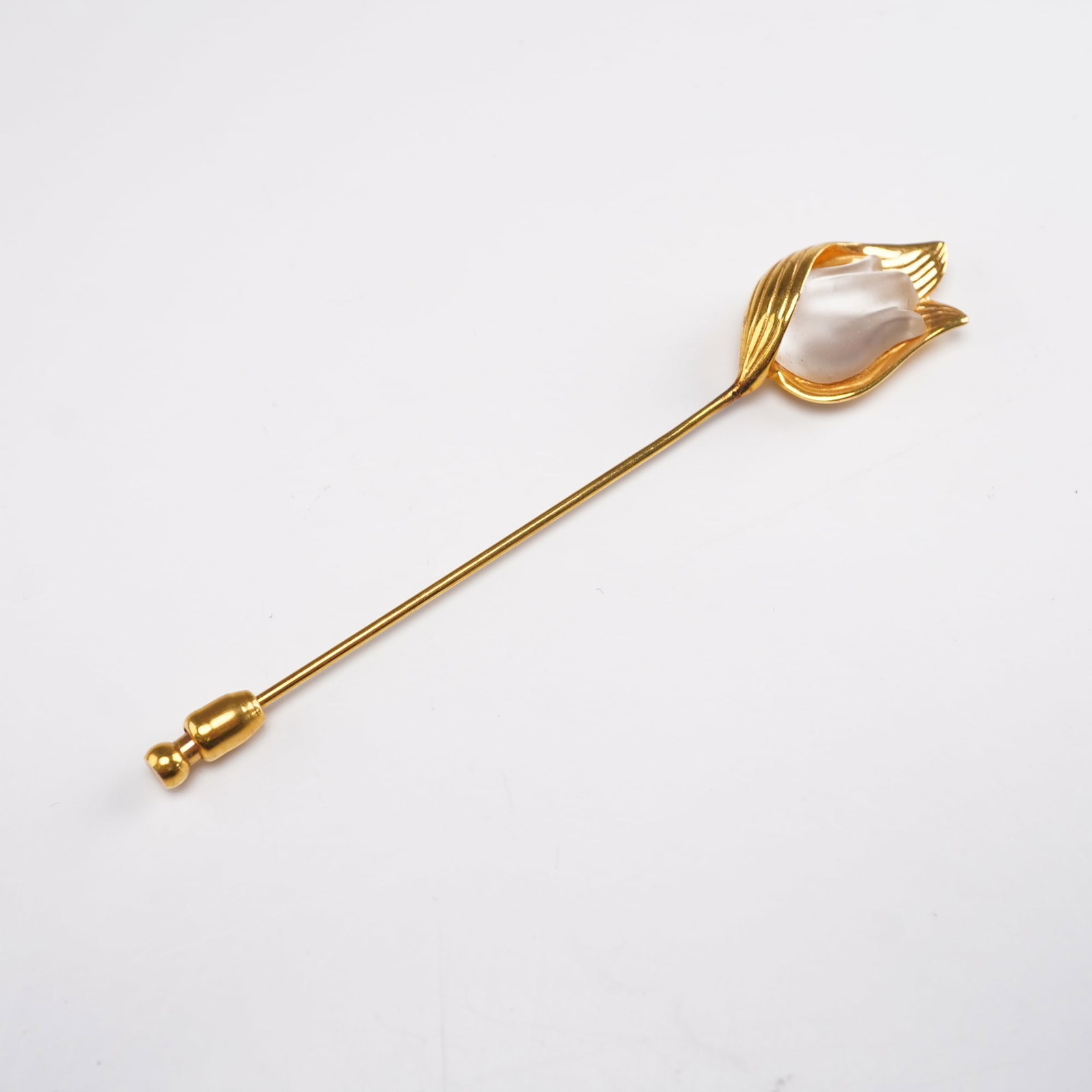 Lalique Crystal and Gilt Tulip Stick Pin: Elegant Lalique crystal and gilt metal stick pin featuring a frosted crystal tulip bud embraced by textured gilt petals and leaves. The floral head is mounted on a slender gold-tone pin with a protect