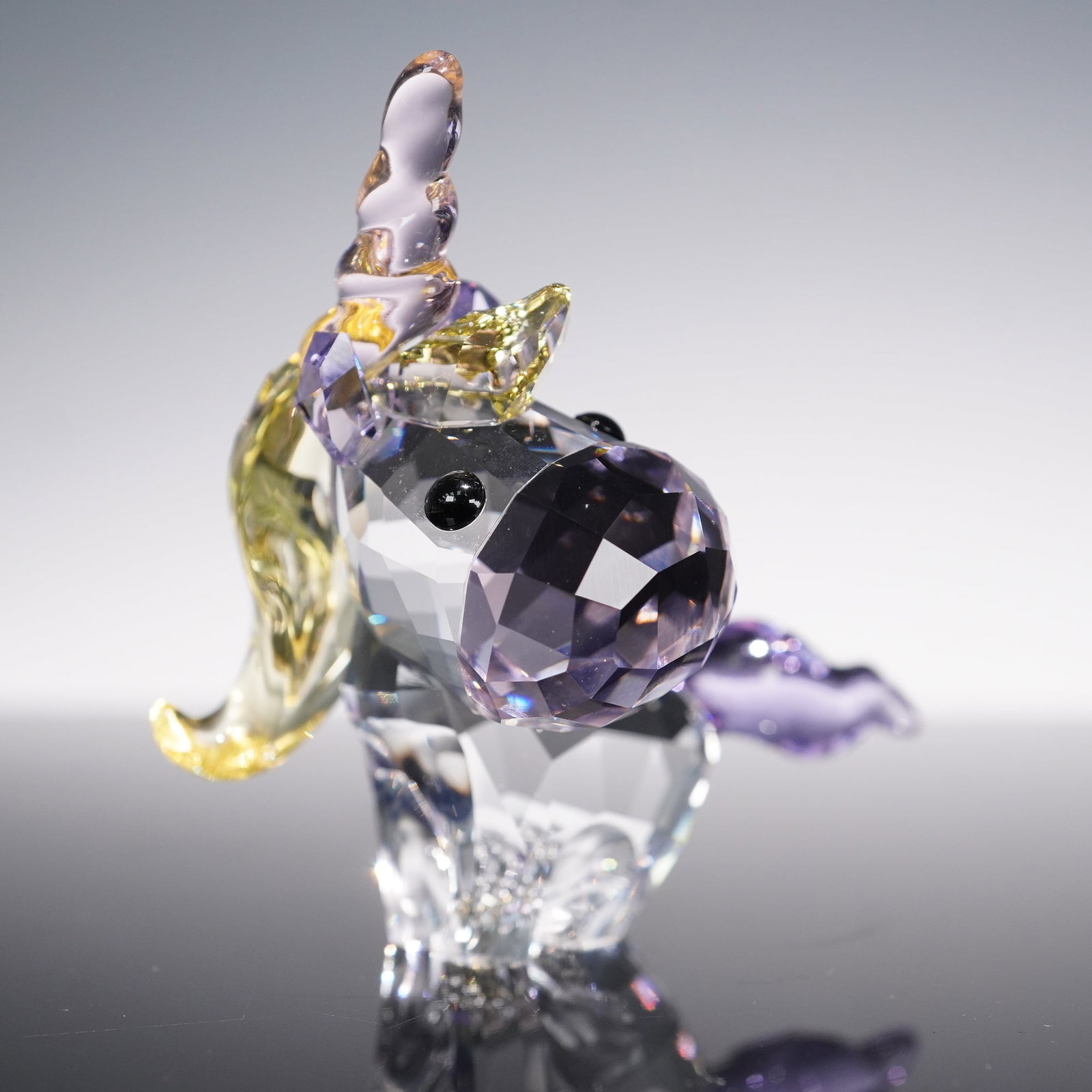 Swarovski Crystal Lovlots Mythical Creatures, Unicorn: Swarovski Lovlots Mythical Creatures Unicorn figurine, crafted in faceted clear and lavender crystal with a vibrant golden mane and horn, purple tail, and expressive jet-black crystal eyes. This whims