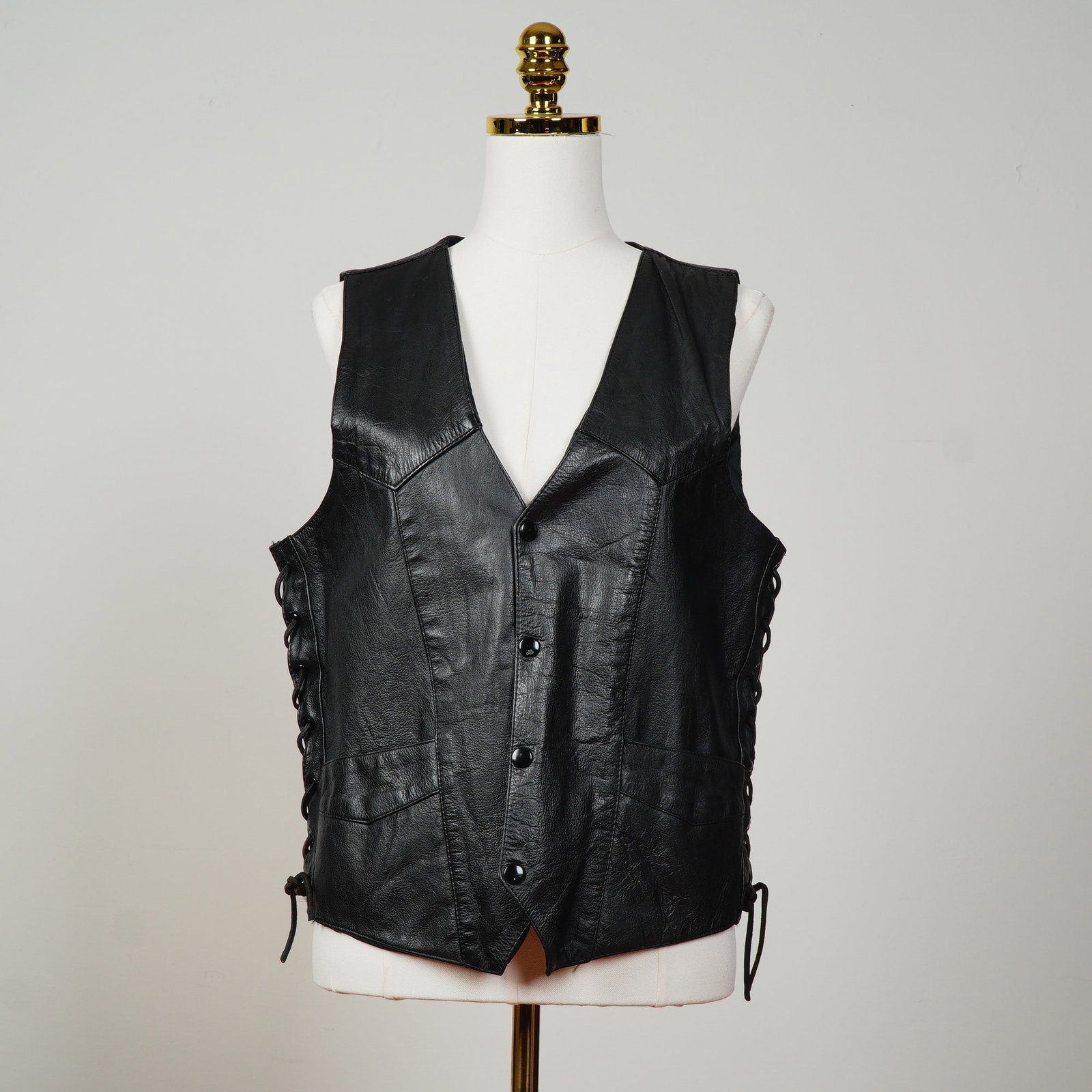 Black Leather Vest and Pants Ensemble: A bold and classic pairing of genuine leather garments, perfect for collectors, bikers, or anyone seeking a timeless edge. The vest, labeled First Genuine Leather, showcases a sleek V-neck cut, lace-u