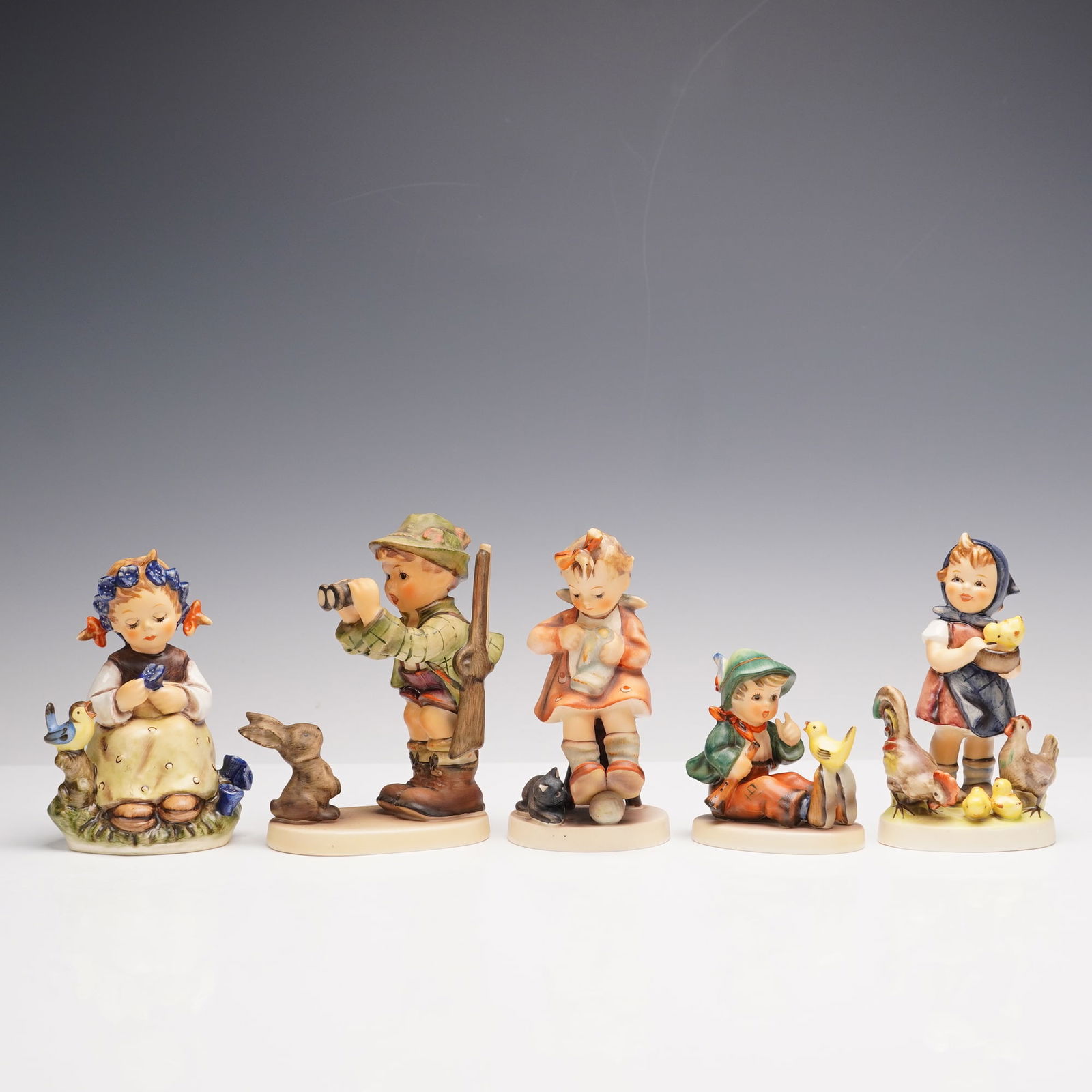 5pc Goebel Hummel Figurines: This delightful set of five Hummel figurines is full of charm and vivid detail. Feeding Time shows a sweet girl surrounded by hens and chicks while Mothers Helper features a young girl cleaning a mug