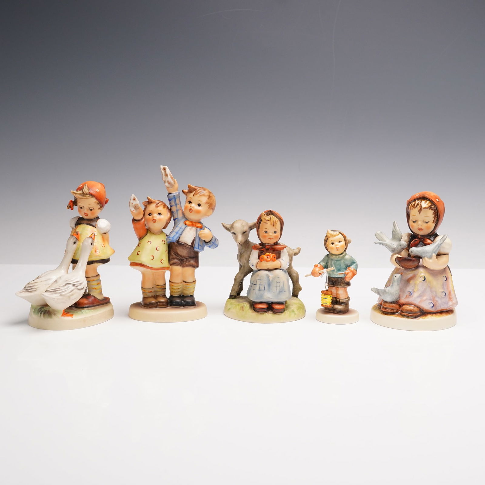 5pc Goebel Hummel Figurines Group Including Goose Girl and Cinderella: A charming ensemble of five Goebel Hummel figurines, each one telling its own sweet story from childhood wonder. This group includes Lantern Fun 2115/B, a little one glowing with delight as their lant