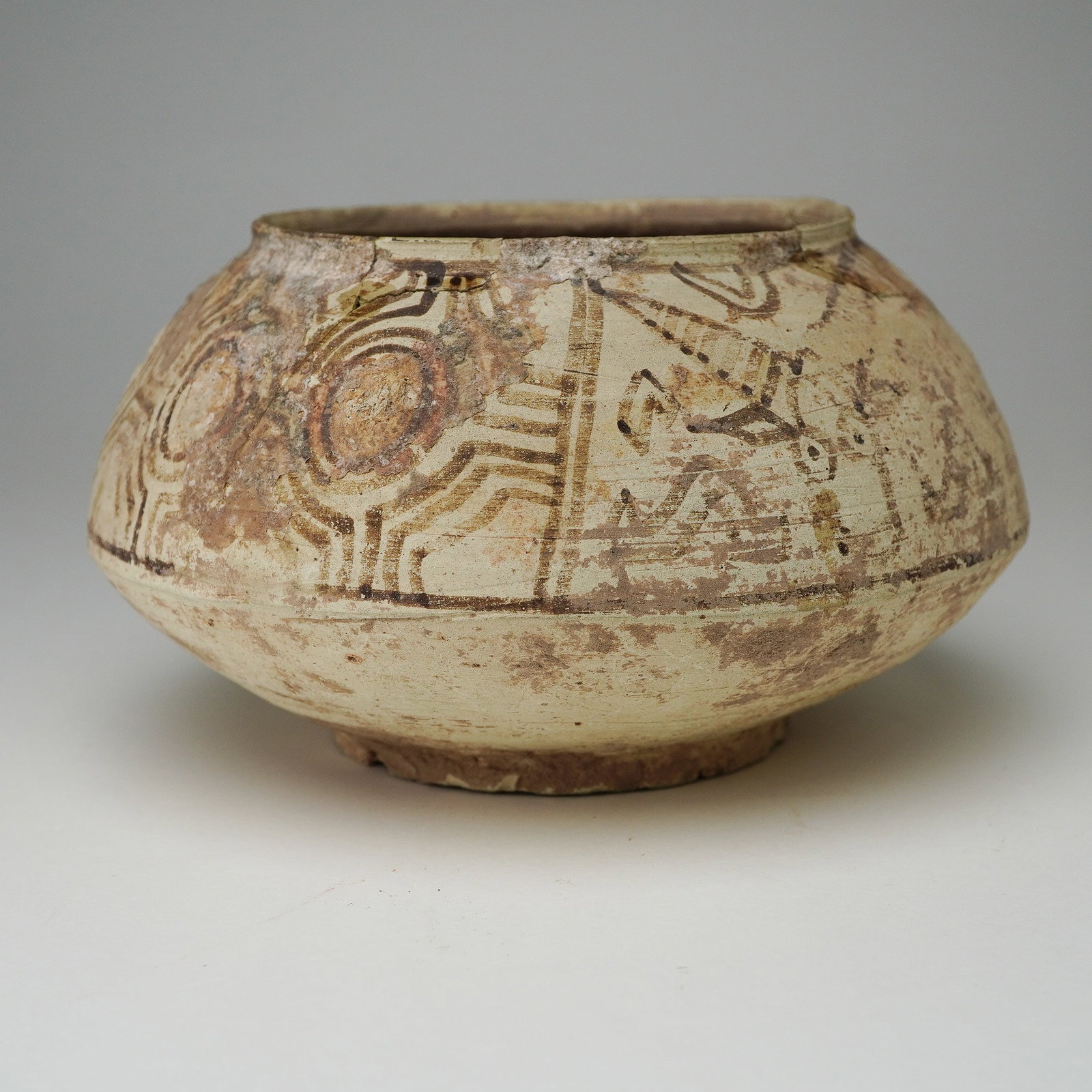 Indus Valley Terracotta Bowl with Goats, c. 2600 - 1300 BCE: This terracotta bowl originates from the Indus Valley civilization and features a globular form with a narrow opening and a flat, ringed base. The bowl is constructed from a light-brown clay, showing 
