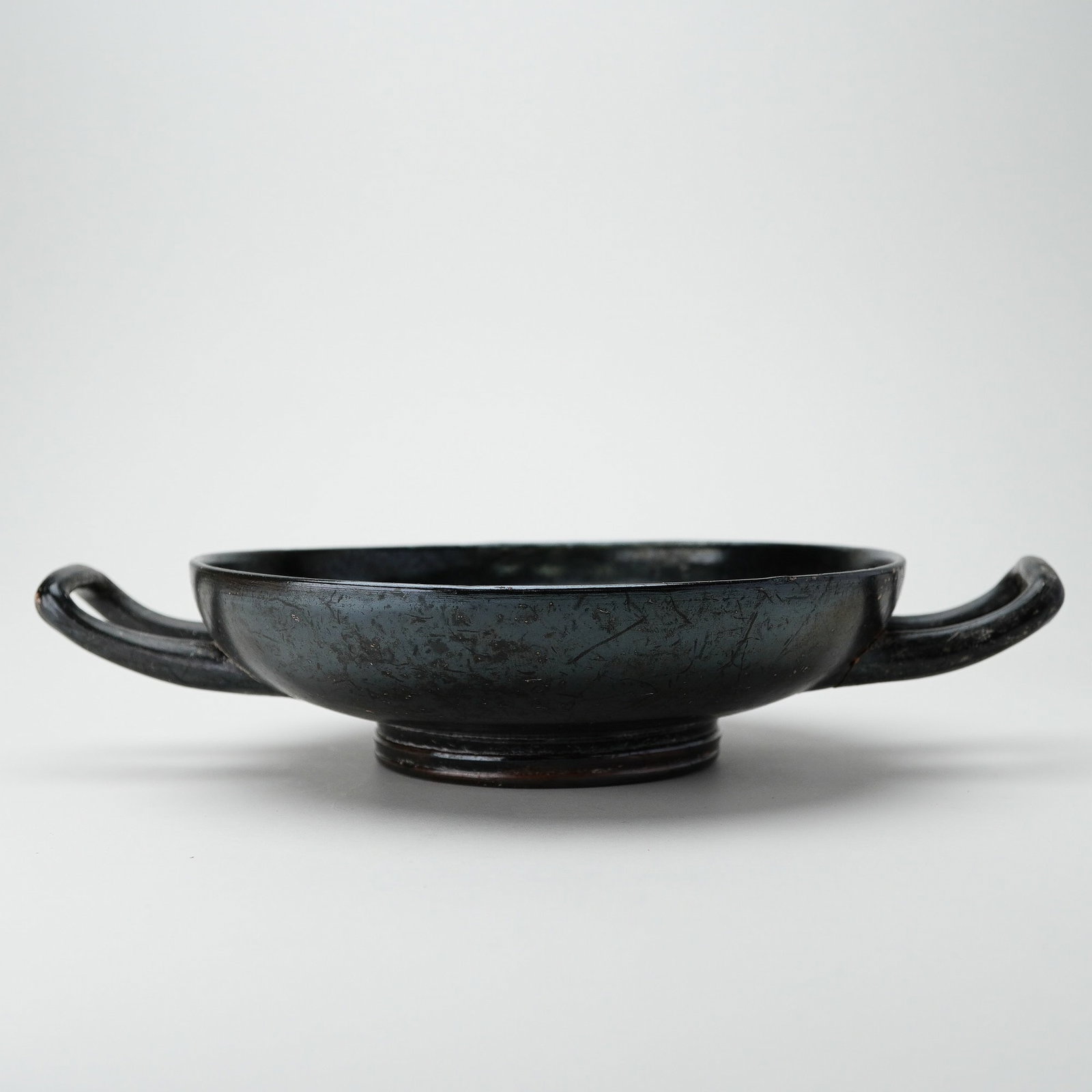 Ancient Italian Bucchero Palmette Bowl, 6th to 5th Century BCE: This is an ancient Italian Bucchero ware bowl from the 6th to 5th century BCE, likely Etruscan in origin. It features a shallow, circular form with a slightly flared rim and two horizontally aligned l