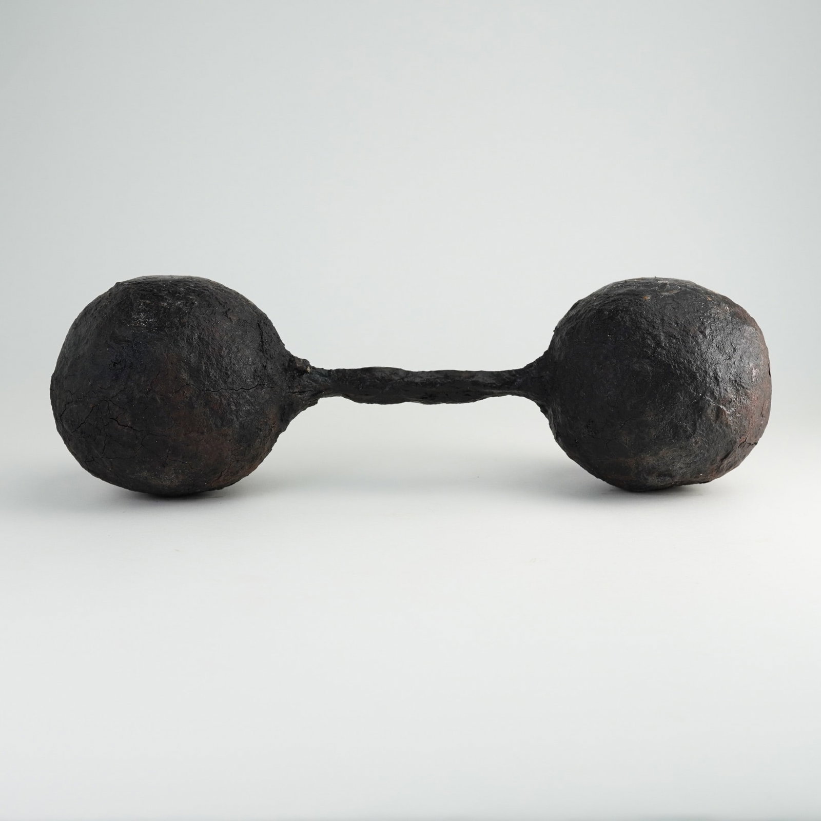 Antique Wrought Iron Naval Bar Shot: Antique wrought iron bar shot consisting of two solid cast iron spheres connected by a central wrought iron rod. This type of ammunition, historically used in naval warfare, was designed to be fired f