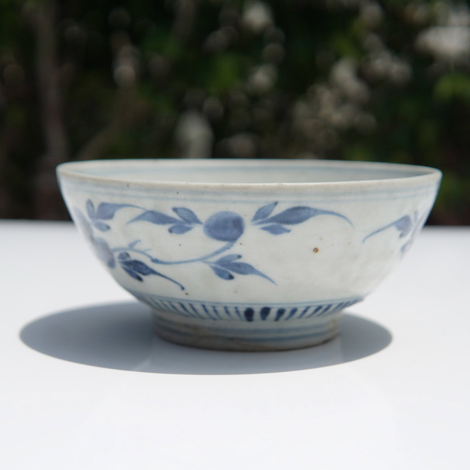 Chinese Late Ming to Early Qing Dynasty White and Blue Bowl: Chinese porcelain bowl, likely dating to the Late Ming to Early Qing Dynasty period (17th - 18th century). The exterior features hand-painted underglaze blue decoration of fruiting branches with leave