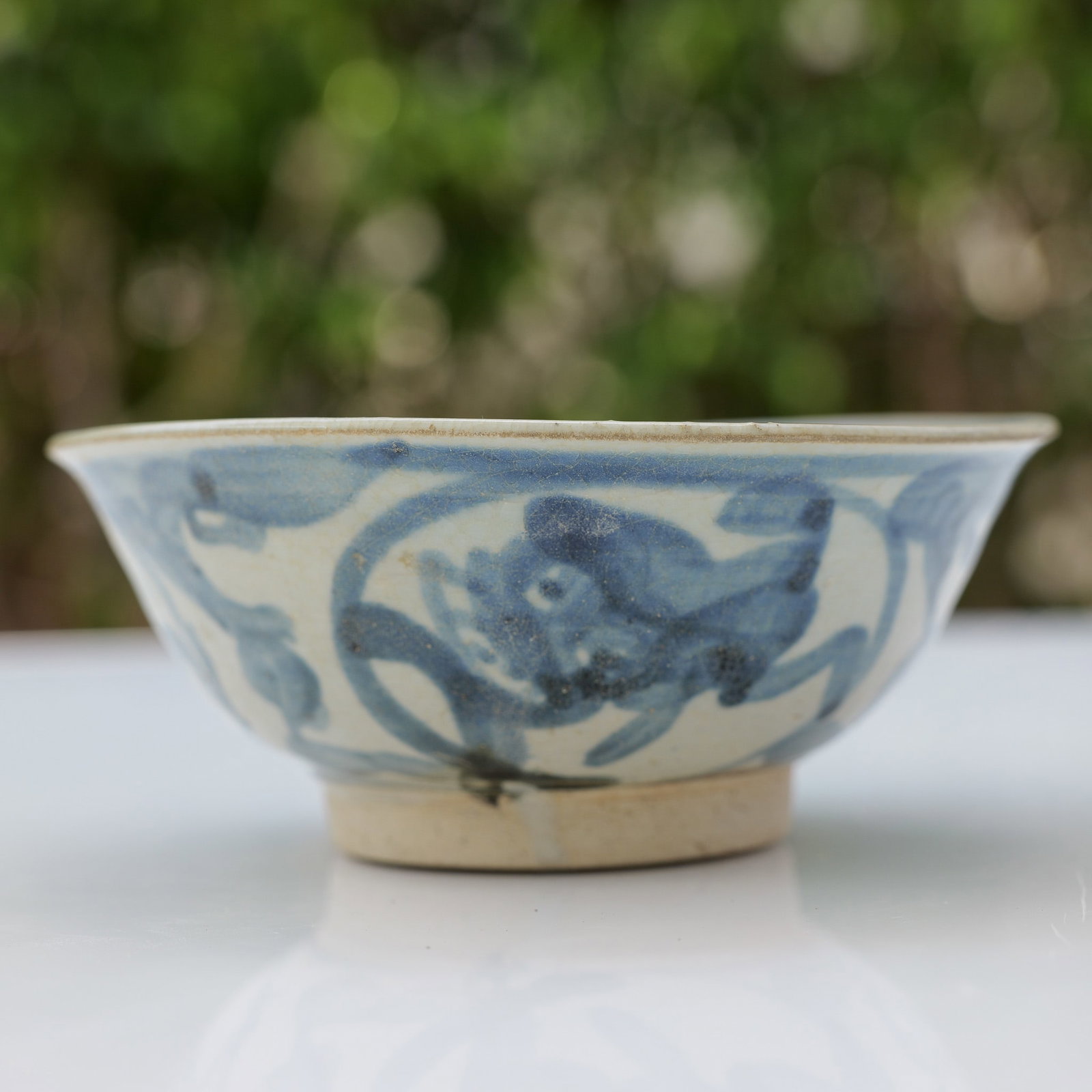 Chinese Ming Period White and Blue Bowl: This Chinese porcelain bowl is attributed to the Ming Dynasty and is decorated in a traditional blue and white palette. The exterior is hand-painted with expressive depictions of mythical creatures, p